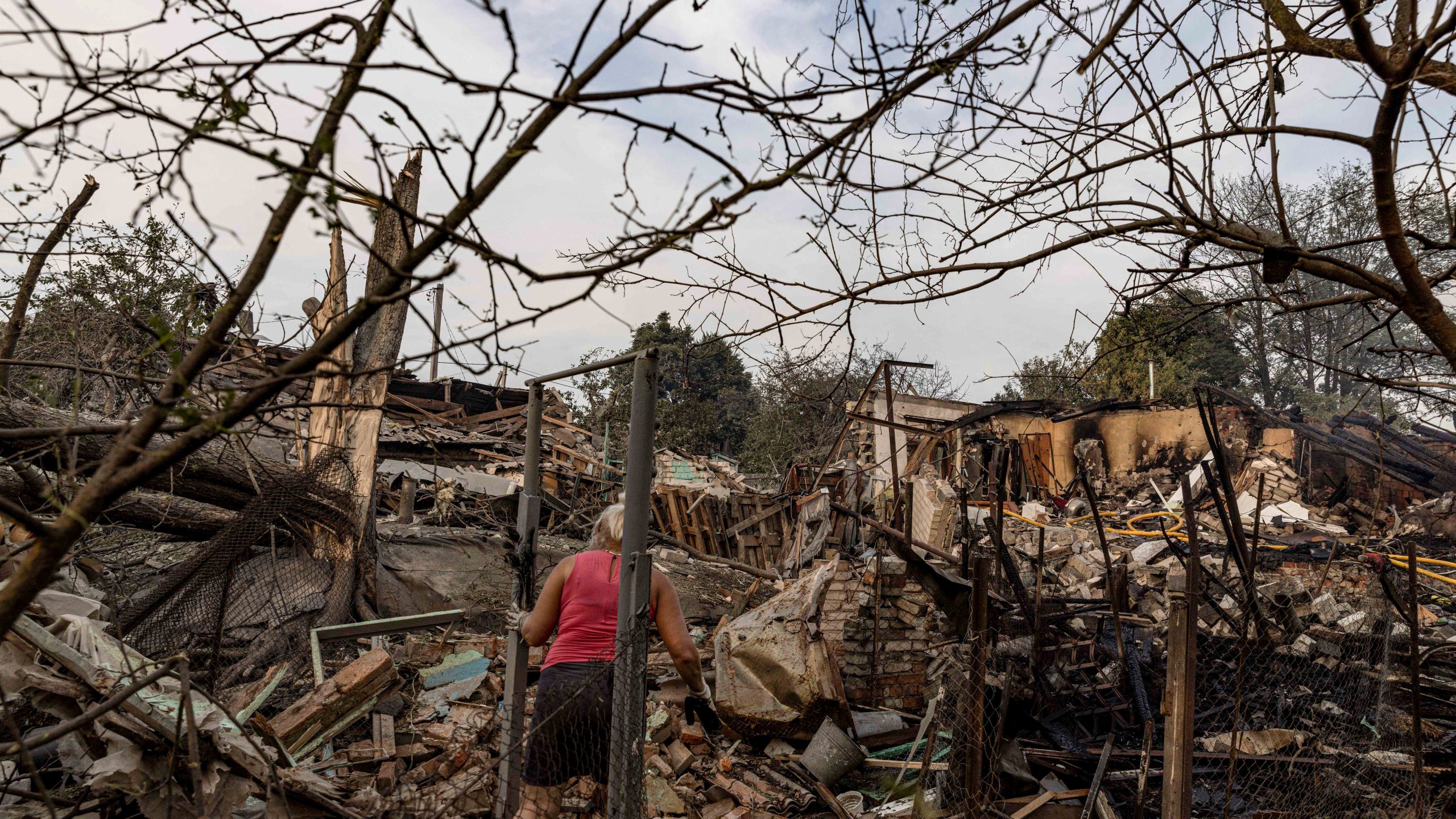 A woman collects her possessions in the yard of a house destroyed after a Russian strike on the residential neighbourhood in Cherkaska Lozova, Kharkiv region, Ukraine, Saturday Aug. 31. 2024. (AP Photo/Yevhen Titov)