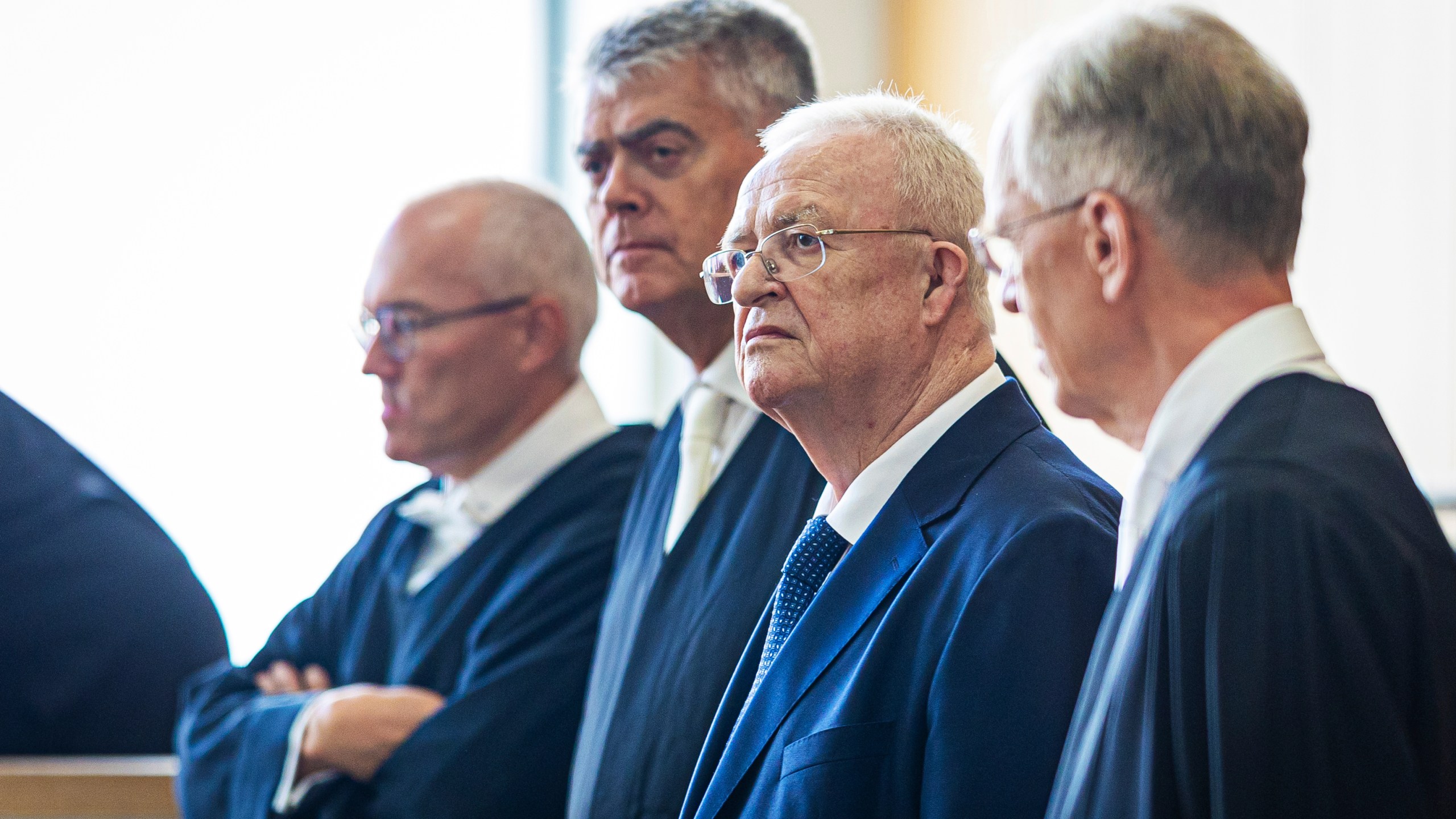 Former Volkswagen Group CEO Martin Winterkorn, second right, stands between his defense lawyers in a hall of the Braunschweig Regional Court in Brunswick, Germany, Tuesday, Sept. 3, 2024. (Moritz Frankenberg/dpa via AP)