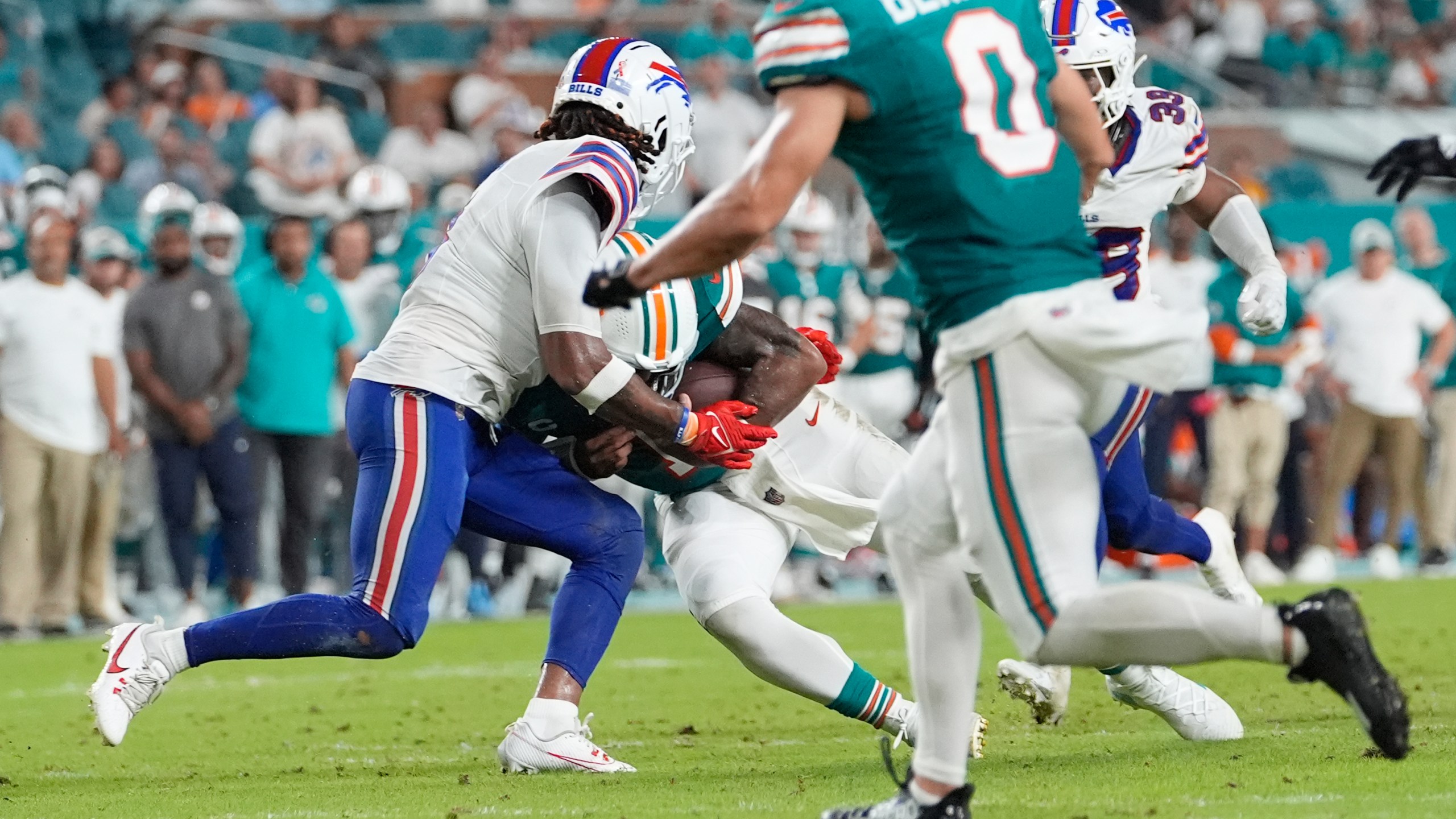 Miami Dolphins quarterback Tua Tagovailoa (1) and Buffalo Bills safety Damar Hamlin (3) collide during the second half of an NFL football game, Thursday, Sept. 12, 2024, in Miami Gardens, Fla. Tagovailoa suffered a concussion on the play. (AP Photo/Lynne Sladky)