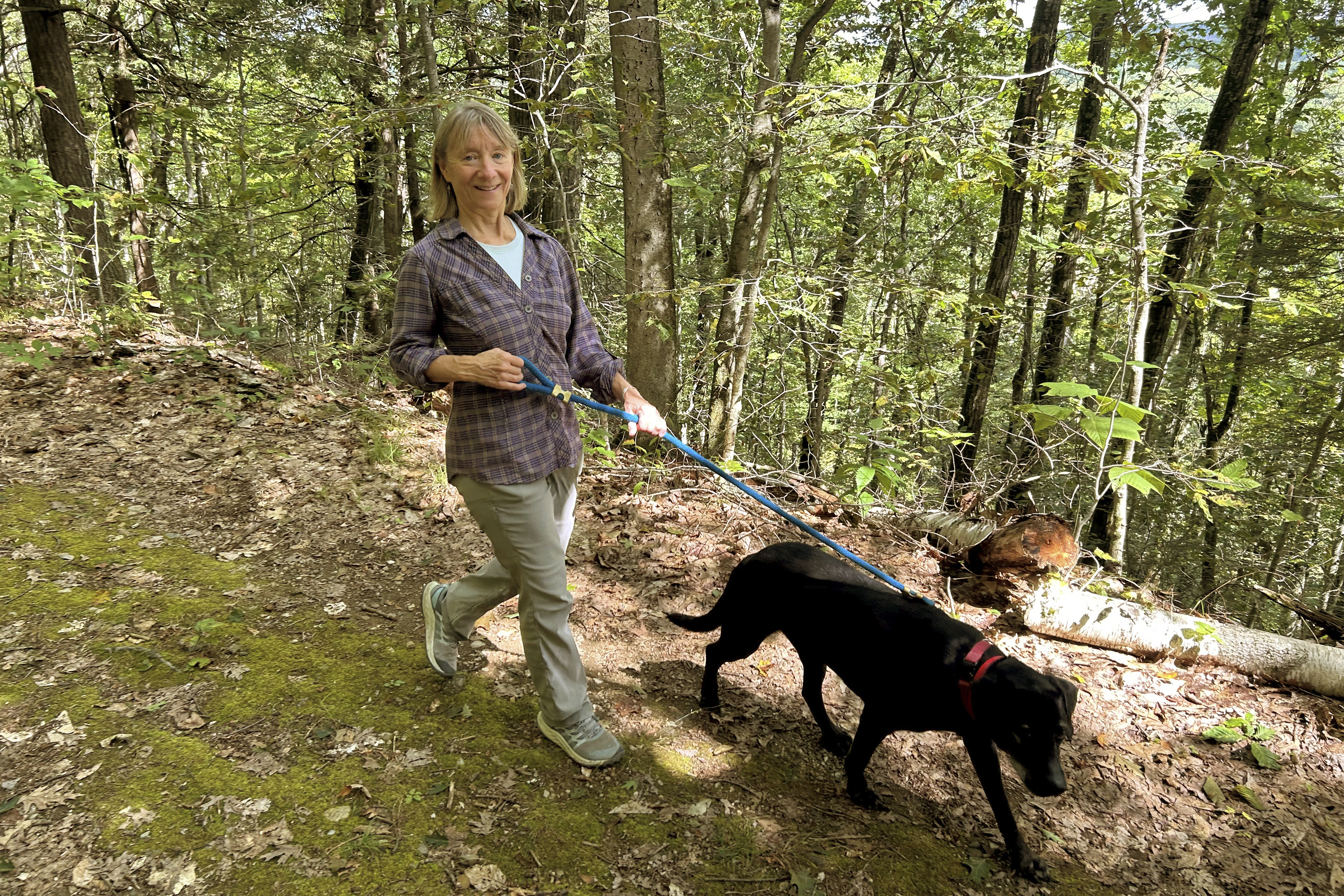 Susannah Johnston, of Croton-on-Hudson, N.Y., walks her dog Ellie on Sept. 8, 2024 in Norfolk, Conn. Johnston, a fit yoga instructor and strength trainer, has been injured three times in incidents involving walking her dog. (Vincent Cohan via AP)