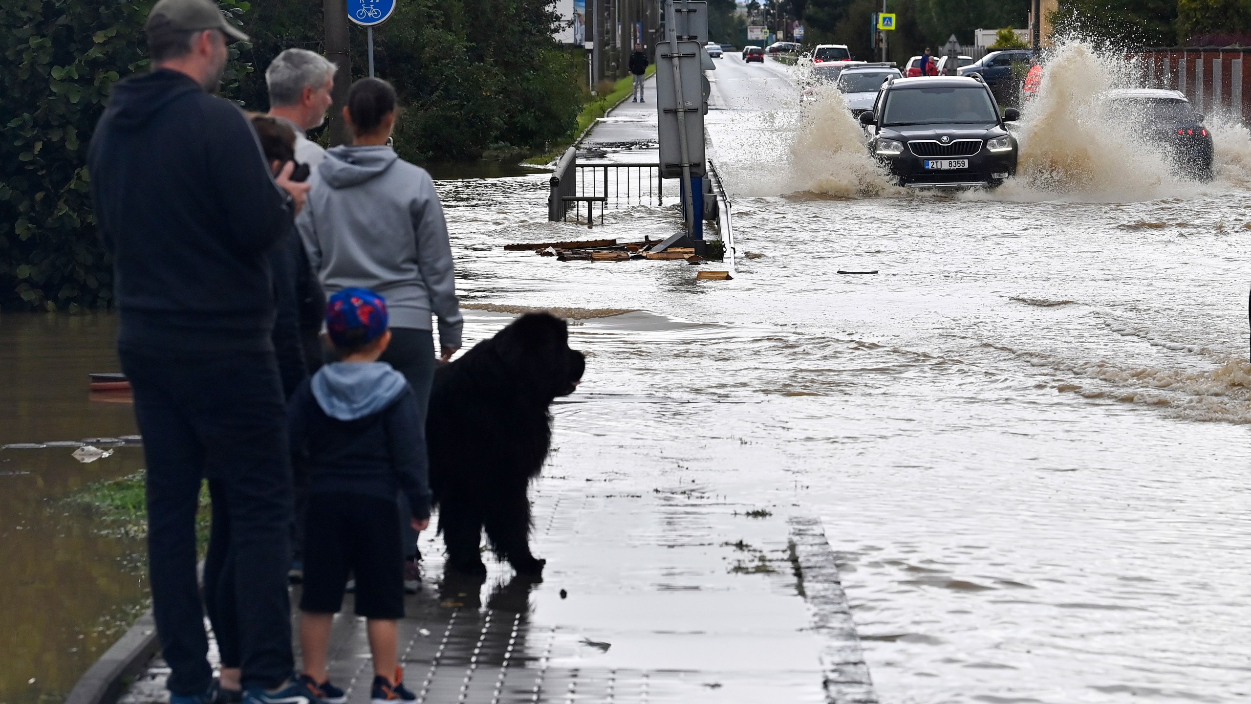 A group of people stand next to a flooded street in Opava, Czech Republic, Sunday Sept. 15, 2024. (Jaroslav Ozana/CTK via AP)