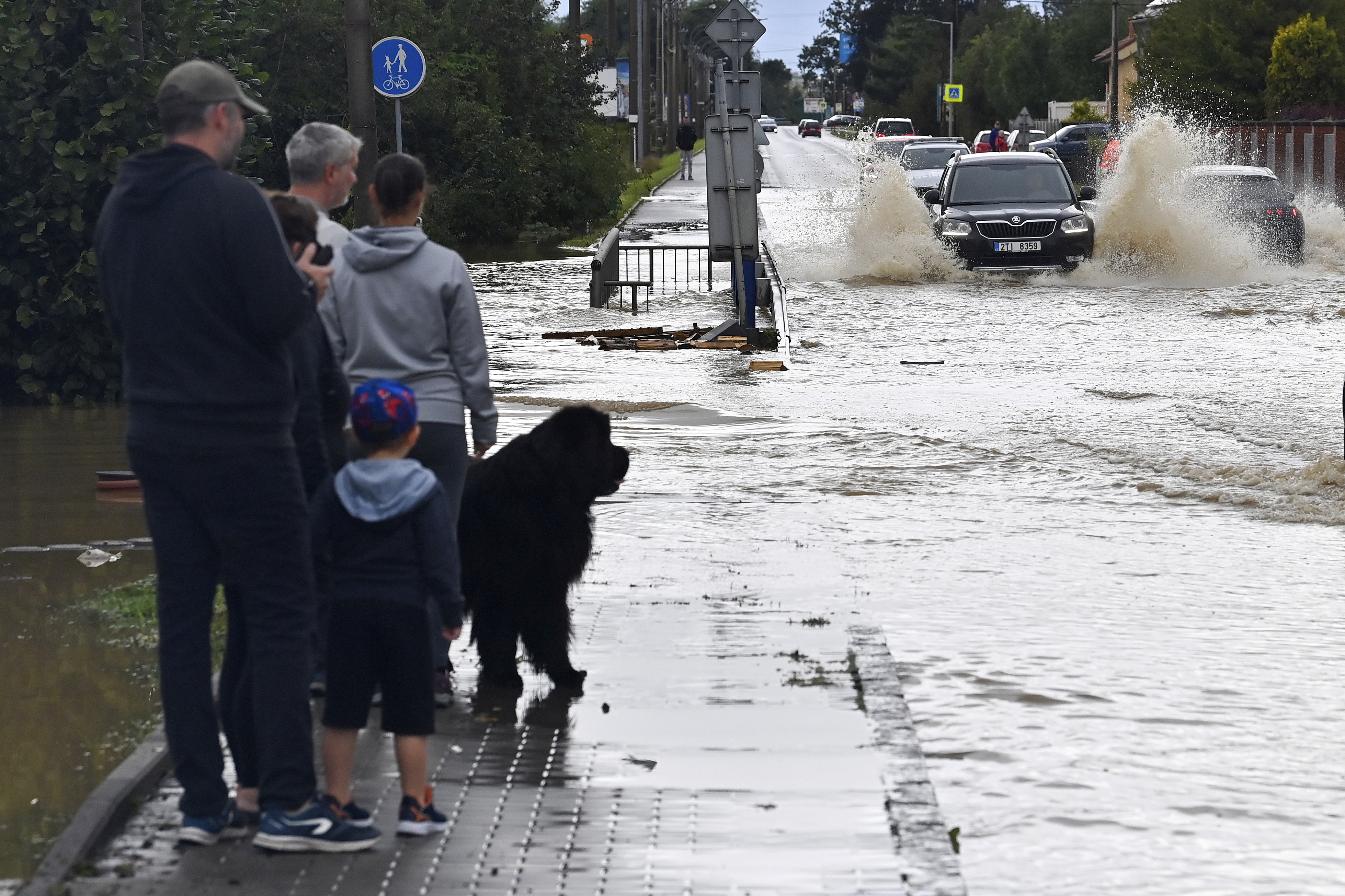 A group of people stand next to a flooded street in Opava, Czech Republic, Sunday Sept. 15, 2024. (Jaroslav Ozana/CTK via AP)