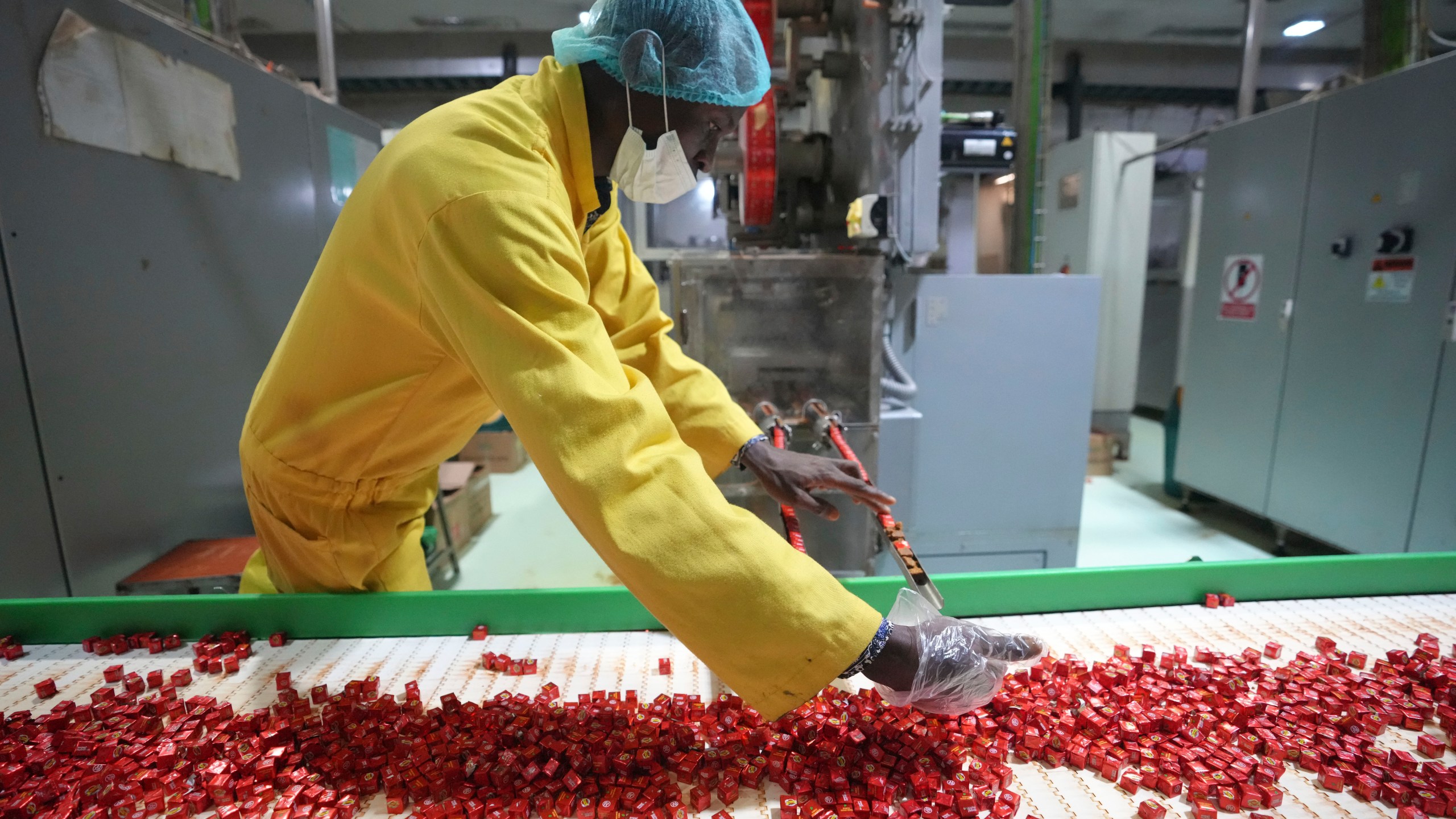 A worker checks bouillon cubes ahead of packaging at the Sweet Nutrition factory in Ota, Nigeria, Thursday, Sept. 12, 2024. (AP Photo/Sunday Alamba)