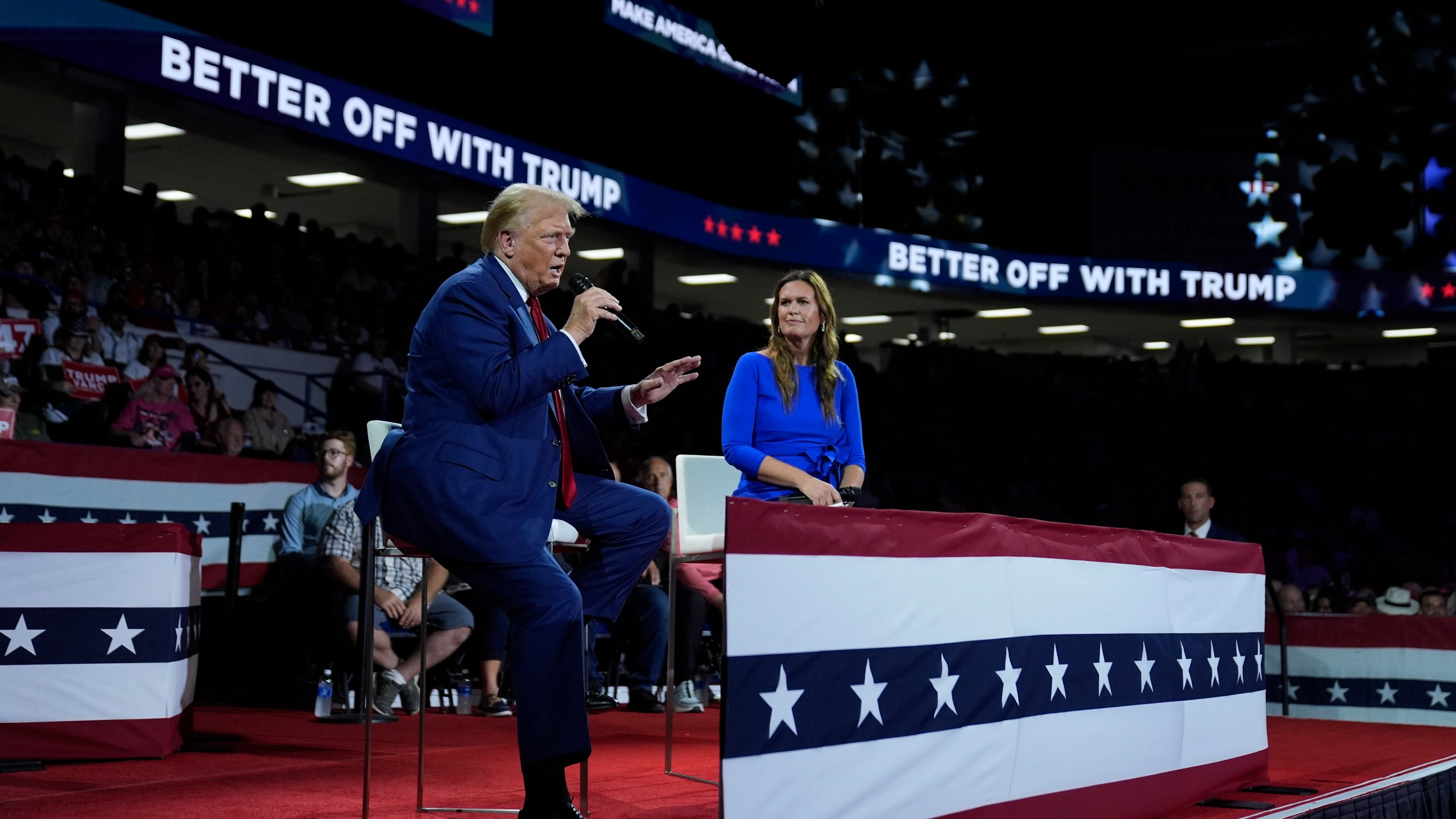 Republican presidential candidate former President Donald Trump, left, on stage with Arkansas Gov. Sarah Huckabee Sanders, right, during a town hall event at the Dort Financial Center, Tuesday, Sept. 17, 2024, in Flint, Mich. (AP Photo/Evan Vucci)