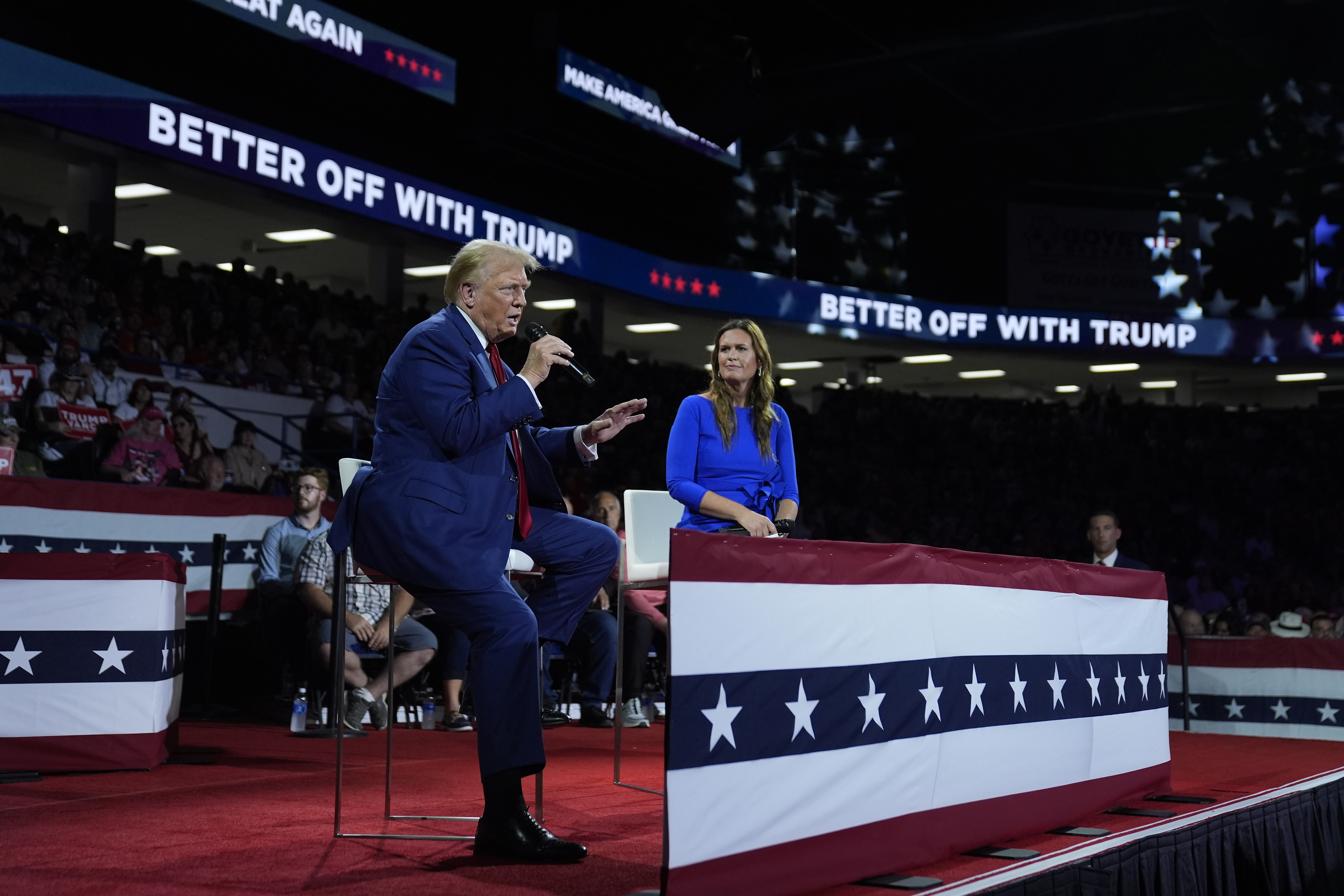 Republican presidential candidate former President Donald Trump, left, on stage with Arkansas Gov. Sarah Huckabee Sanders, right, during a town hall event at the Dort Financial Center, Tuesday, Sept. 17, 2024, in Flint, Mich. (AP Photo/Evan Vucci)