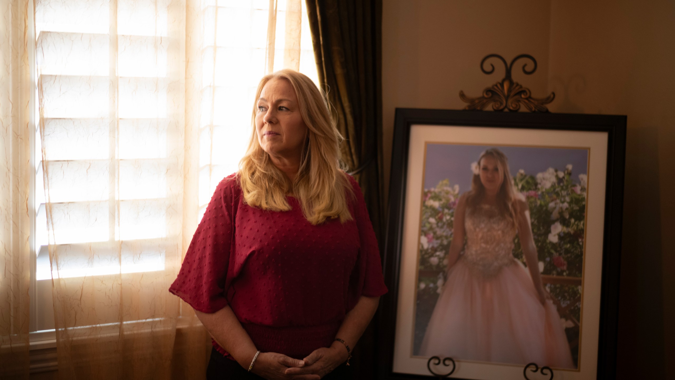 Christine Capelouto, whose daughter, Alexandra, died from a fentanyl overdose, stands for a photo beside her daughter's prom picture in Temecula, Calif., Tuesday, Sept. 17, 2024. (AP Photo/Jae C. Hong)