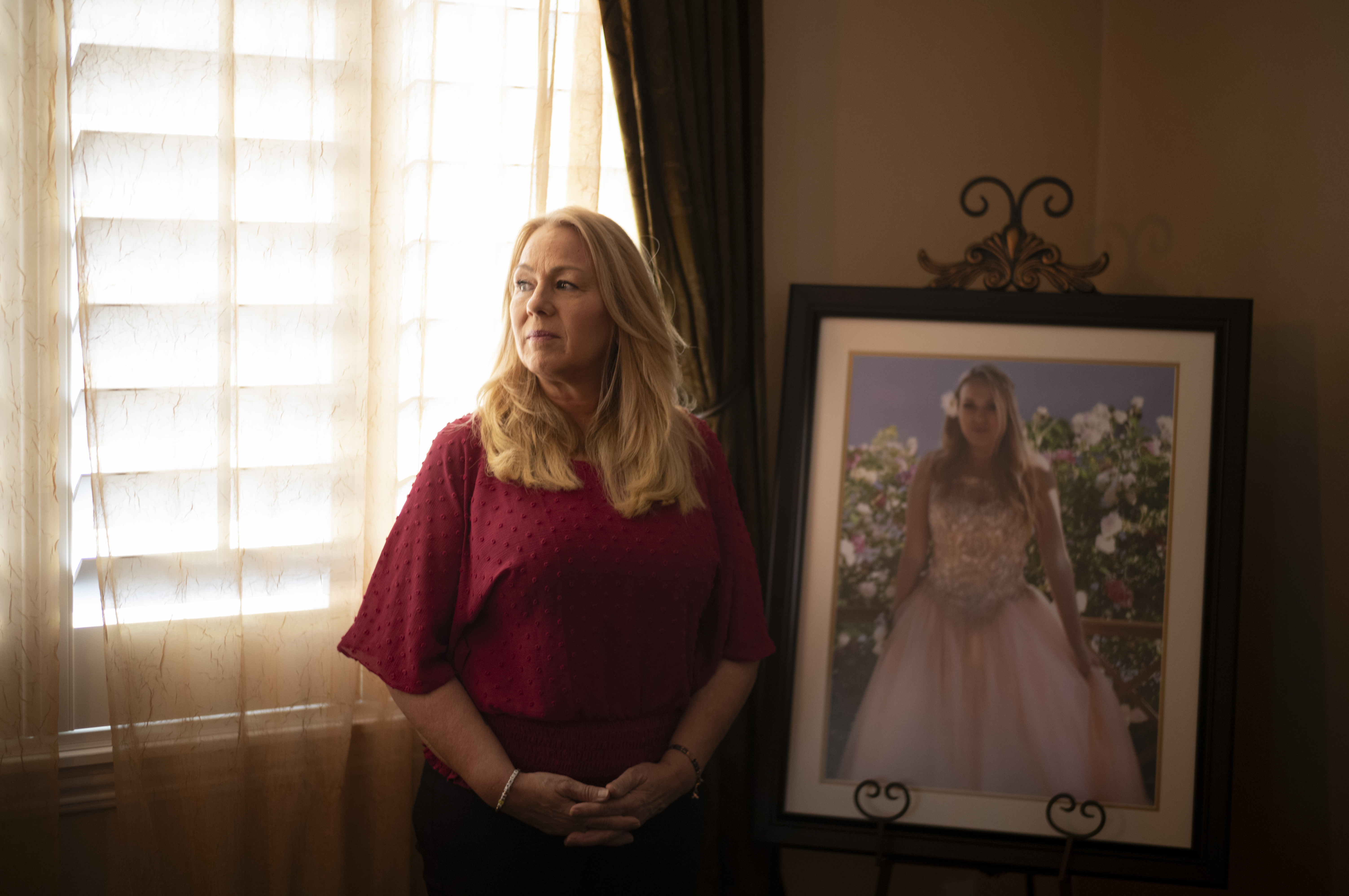 Christine Capelouto, whose daughter, Alexandra, died from a fentanyl overdose, stands for a photo beside her daughter's prom picture in Temecula, Calif., Tuesday, Sept. 17, 2024. (AP Photo/Jae C. Hong)