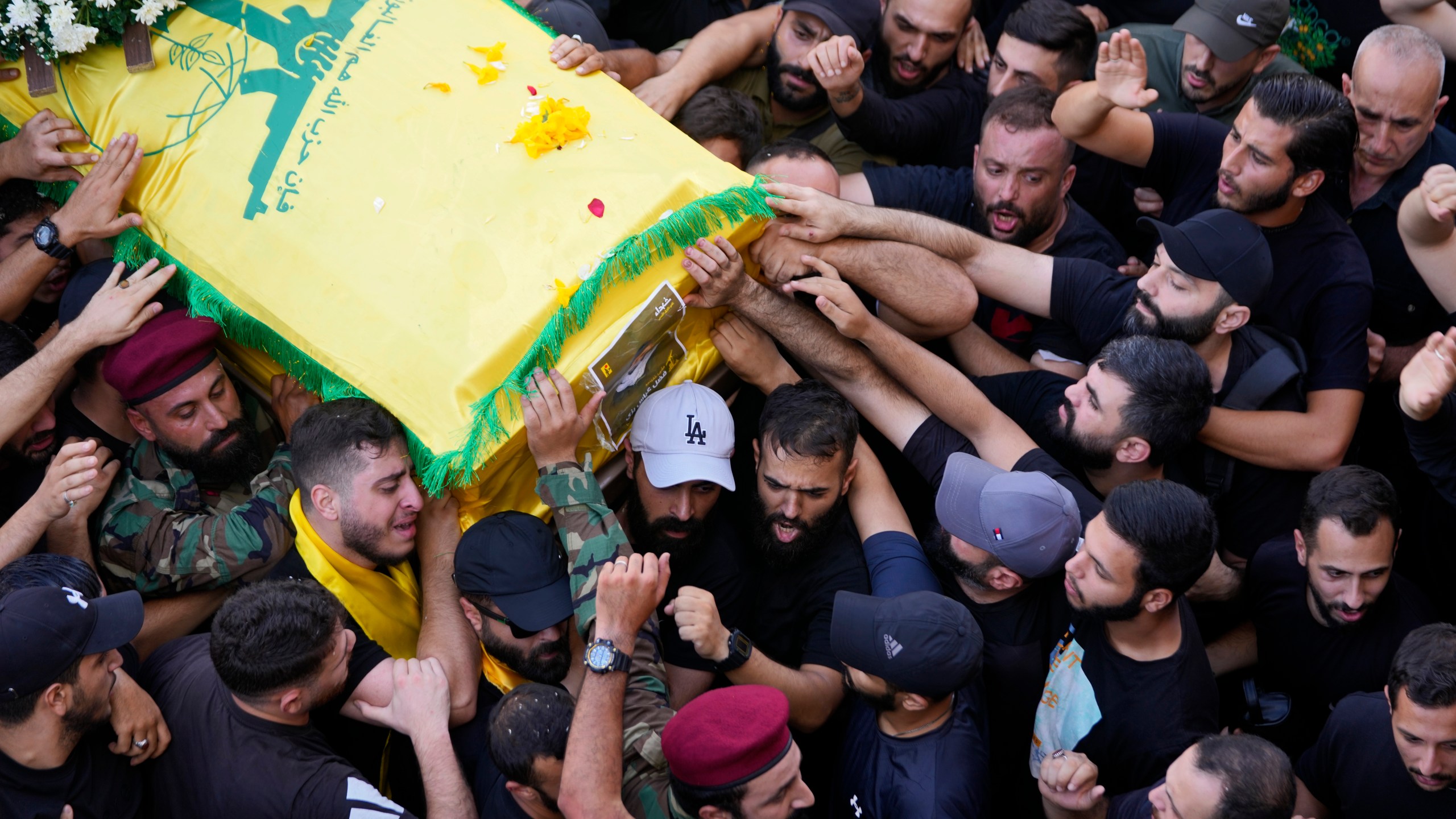 Hezbollah members carry the coffin of their comrade who was killed on Wednesday when a handheld device exploded, during a funeral procession in the southern suburbs of Beirut, Thursday, Sept. 19, 2024. (AP Photo/Hussein Malla)