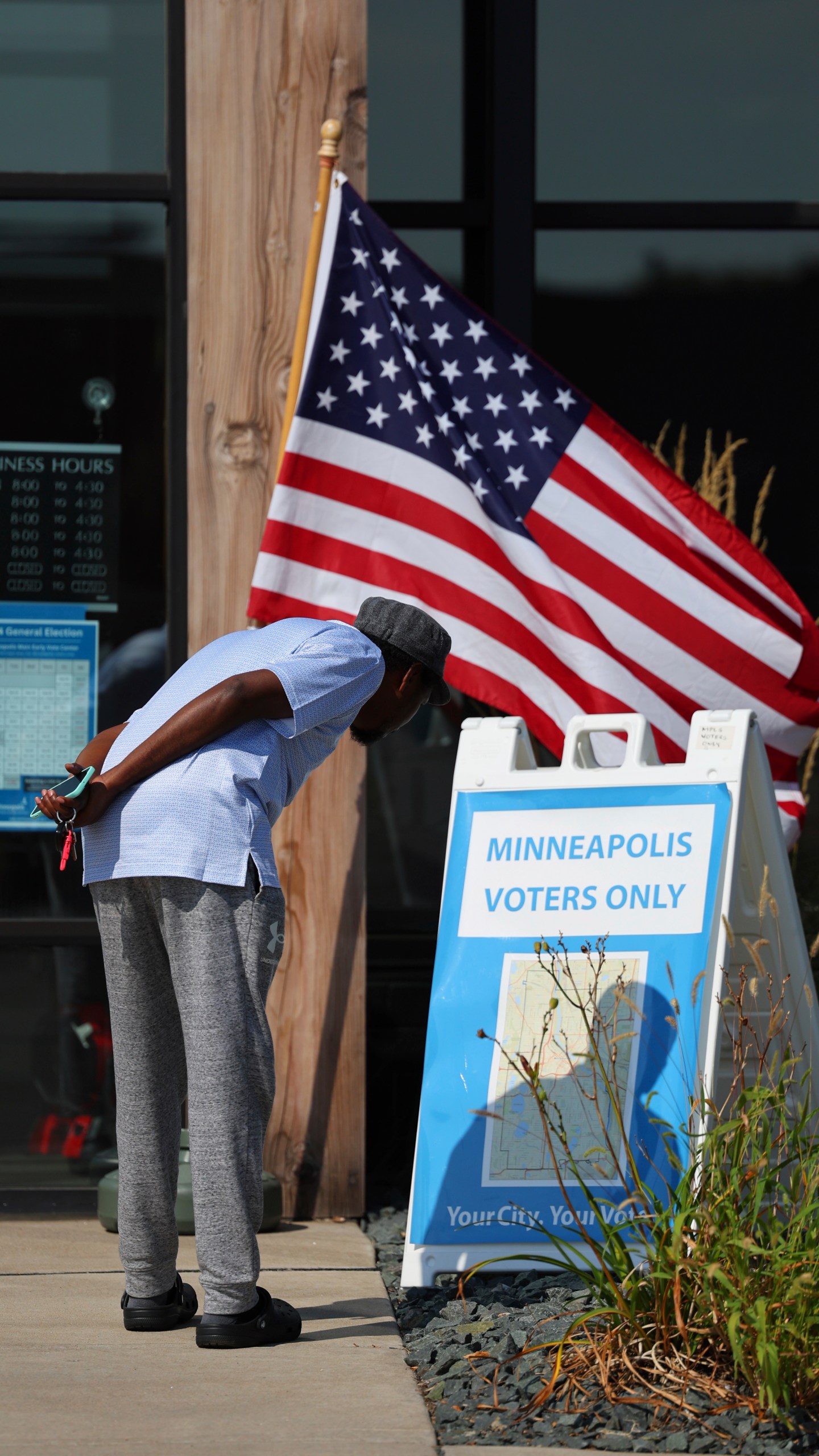 A member of the public looks at a Minneapolis map outside of the City of Minneapolis early voting center, Thursday, Sept. 19, 2024, in St. Paul, Minn. In-person voting in the 2024 presidential contest begins Friday in three states, including Democratic vice presidential candidate Tim Walz's home state of Minnesota, with just over six weeks left before Election Day. (AP Photo/Adam Bettcher)