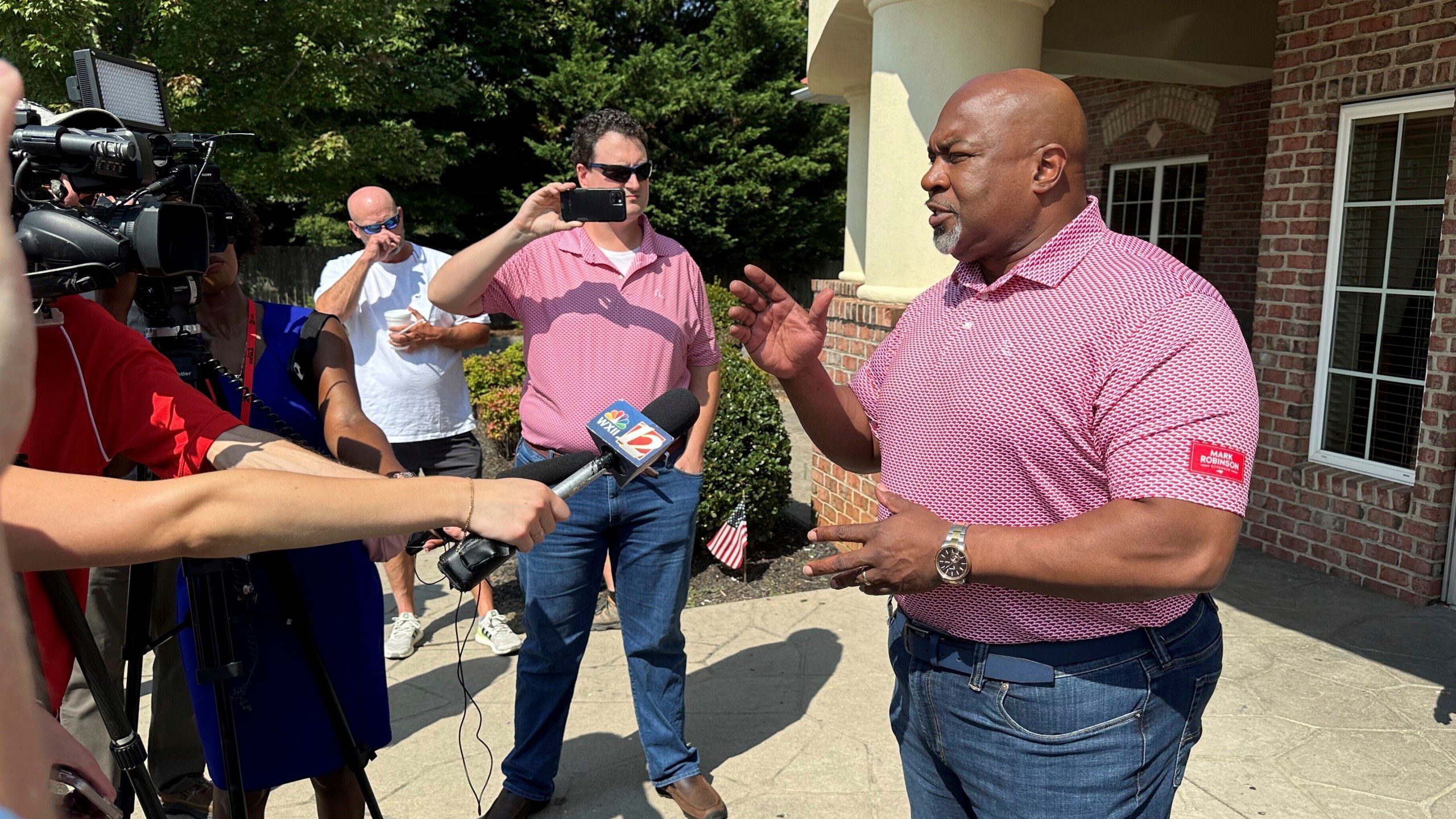 North Carolina Republican gubernatorial candidate Mark Robinson, right, speaks with reporters outside the Olympic Family Restaurant in Colfax, N.C., where Robinson held a campaign event on Monday, Aug. 26, 2024. (AP Photo/Gary D. Robertson)