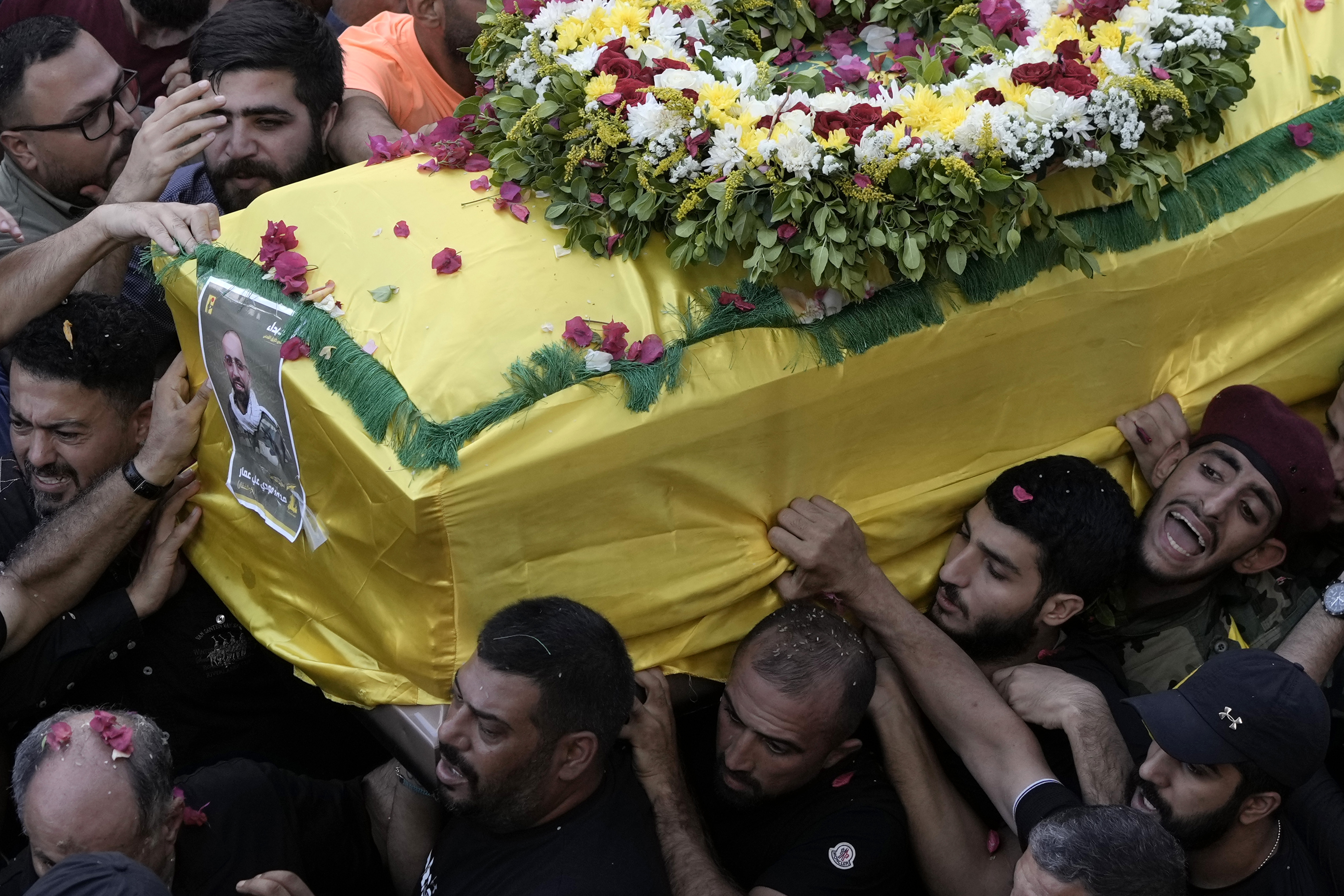 FILE - Hezbollah fighters carry one of the coffins of four fallen comrades who were killed Tuesday after their handheld pagers exploded, in the southern suburb of Beirut, Wednesday, Sept. 18, 2024. (AP Photo/Bilal Hussein, File)