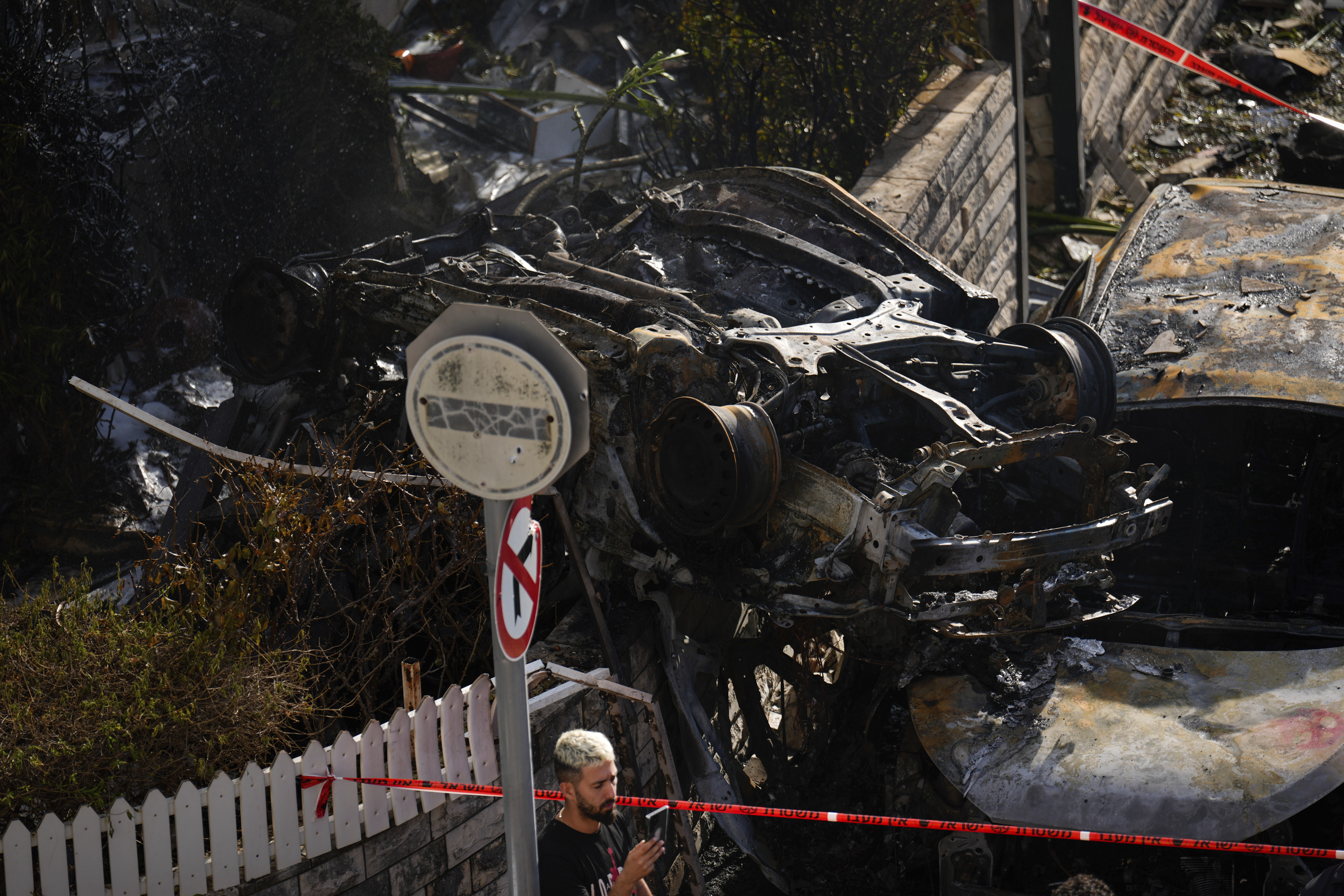 A man looks at the site hit by a rocket fired from Lebanon, in Kiryat Bialik, northern Israel, on Sunday, Sept. 22, 2024. (AP Photo//Ariel Schalit)