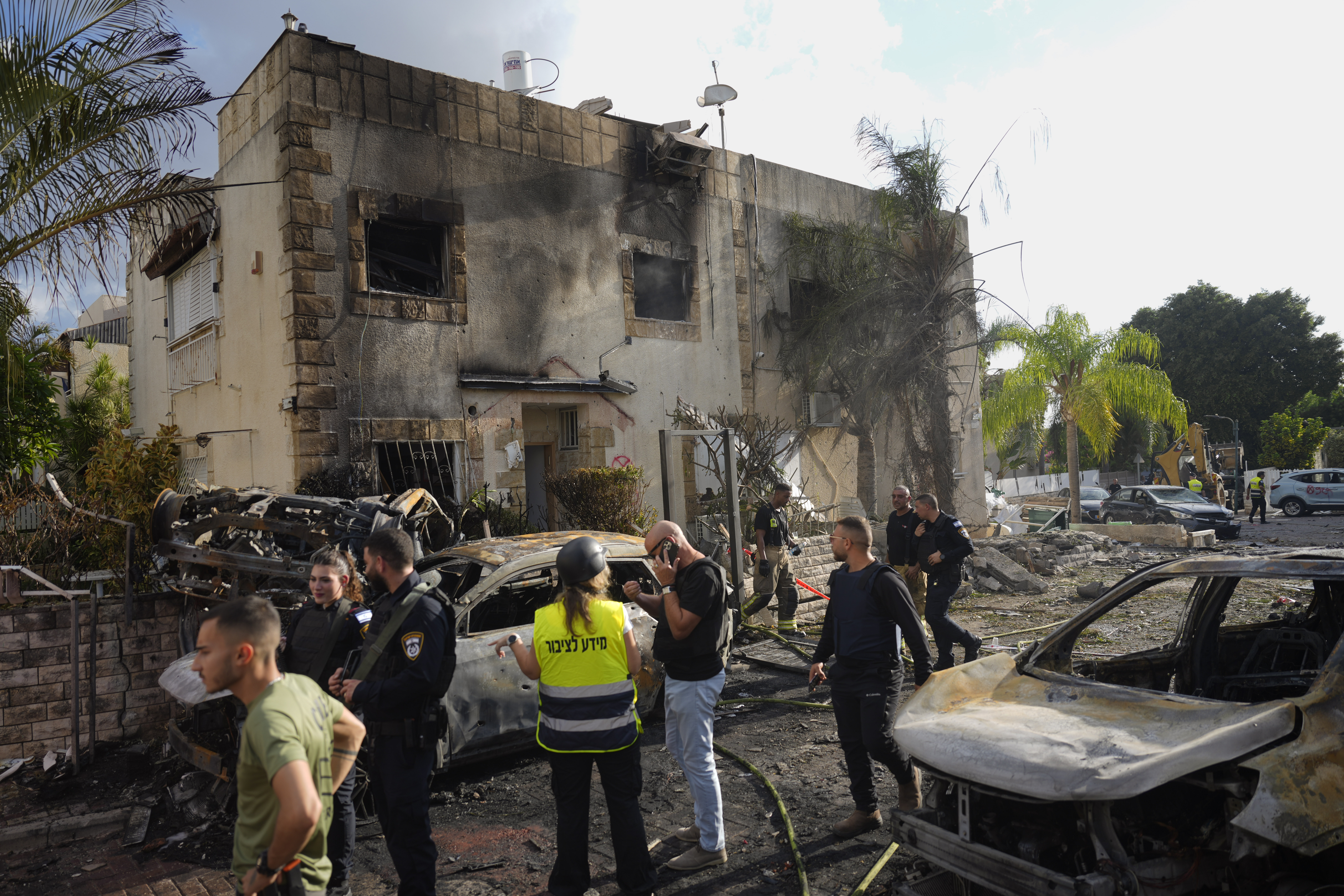 Israeli security forces examine the site hit by a rocket fired from Lebanon, in Kiryat Bialik, northern Israel, on Sunday, Sept. 22, 2024. (AP Photo//Ariel Schalit)