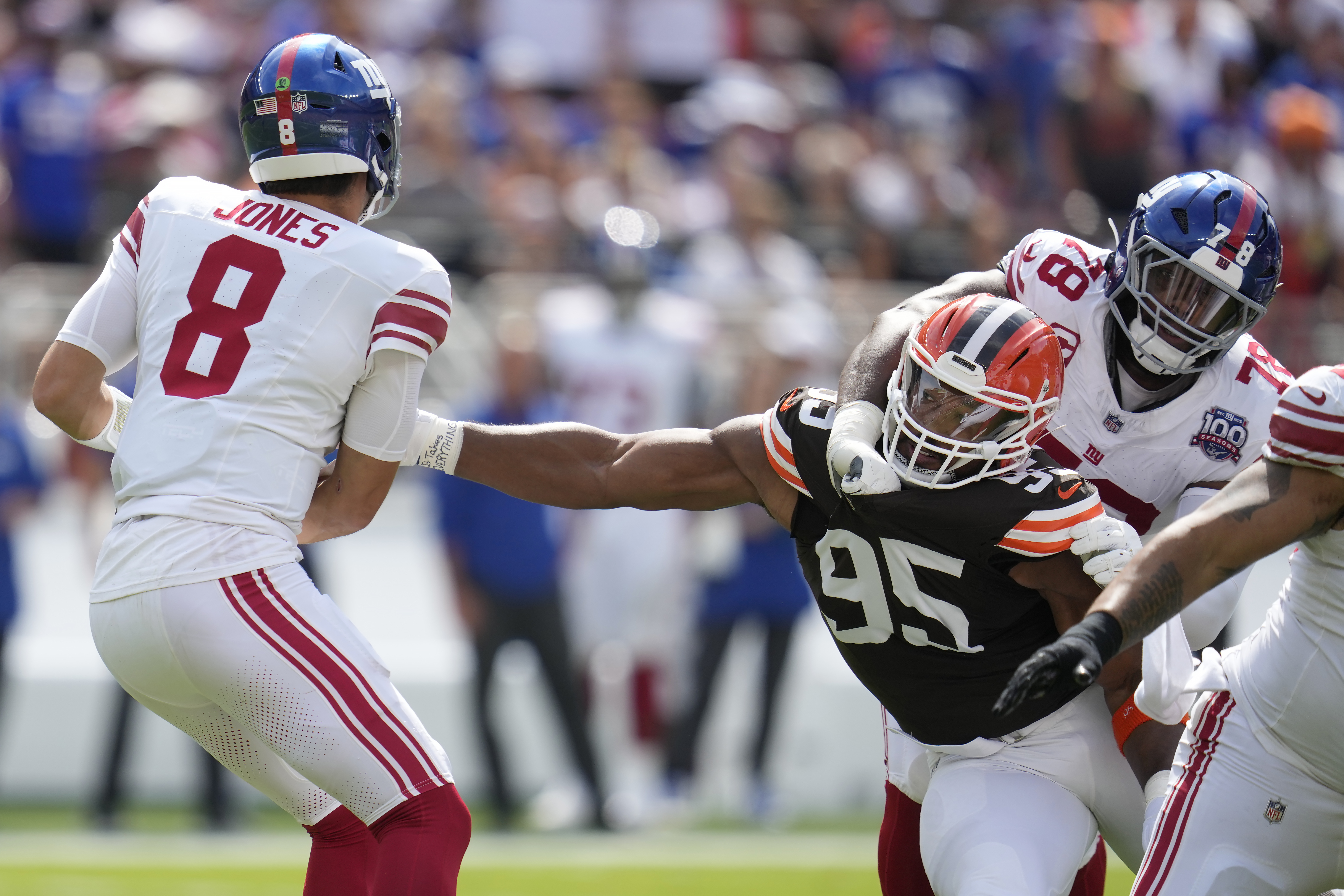 Cleveland Browns defensive end Myles Garrett (95) reaches for New York Giants quarterback Daniel Jones (8) while being blocked by offensive tackle Andrew Thomas (78) during the first half of an NFL football game, Sunday, Sept. 22, 2024 in Cleveland. (AP Photo/Sue Ogrocki)