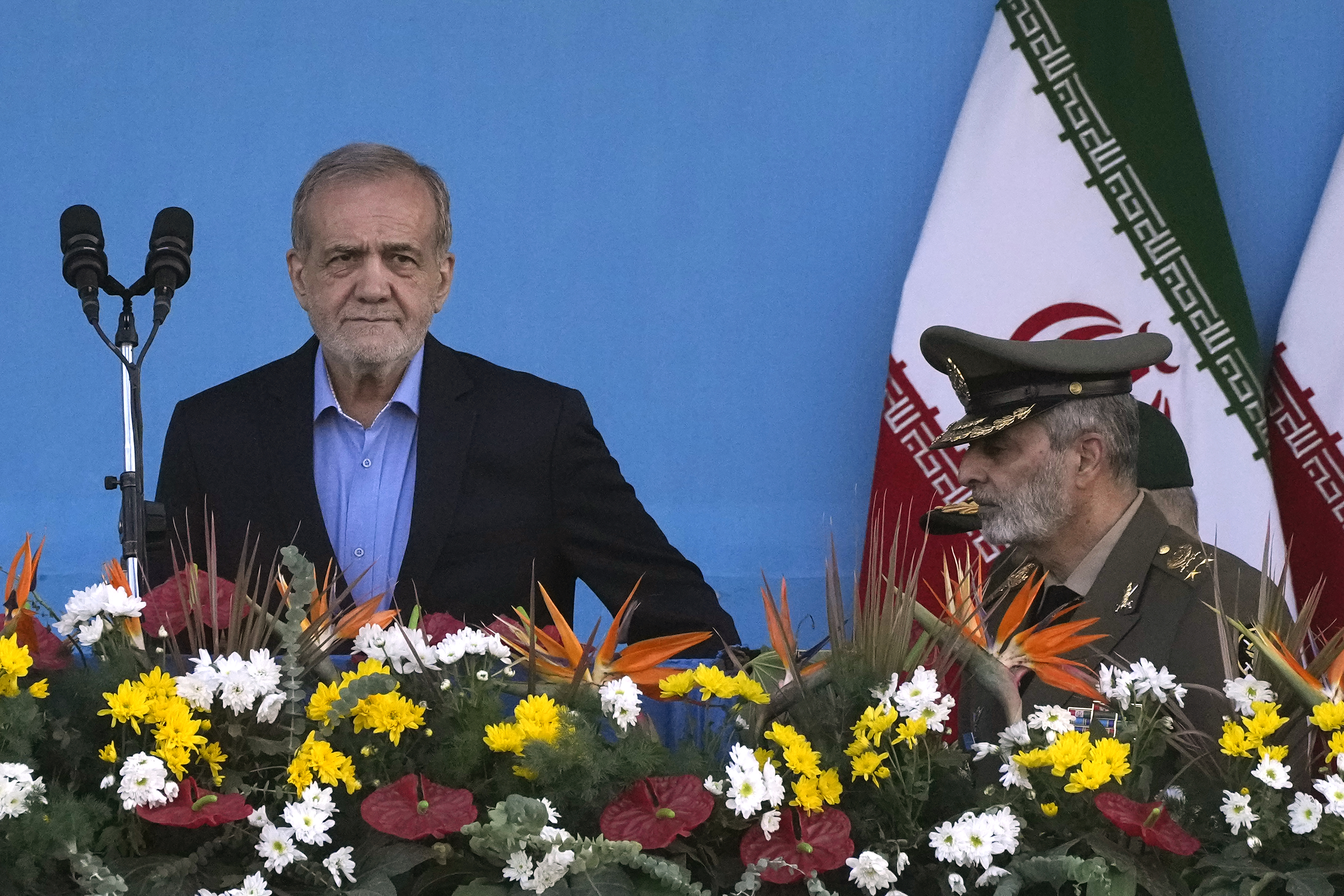 Iranian President Masoud Pezeshkian, left, arrives at the podium, accompanied by the army commander Gen. Abdolrahim Mousavi during an annual armed forces parade marking anniversary of the beginning of war against Iran by former Iraqi Dictator Saddam Hussein 44 years ago, in front of the shrine of the late revolutionary founder Ayatollah Khomeini, just outside Tehran, Iran, Saturday, Sept. 21, 2024. (AP Photo/Vahid Salemi)