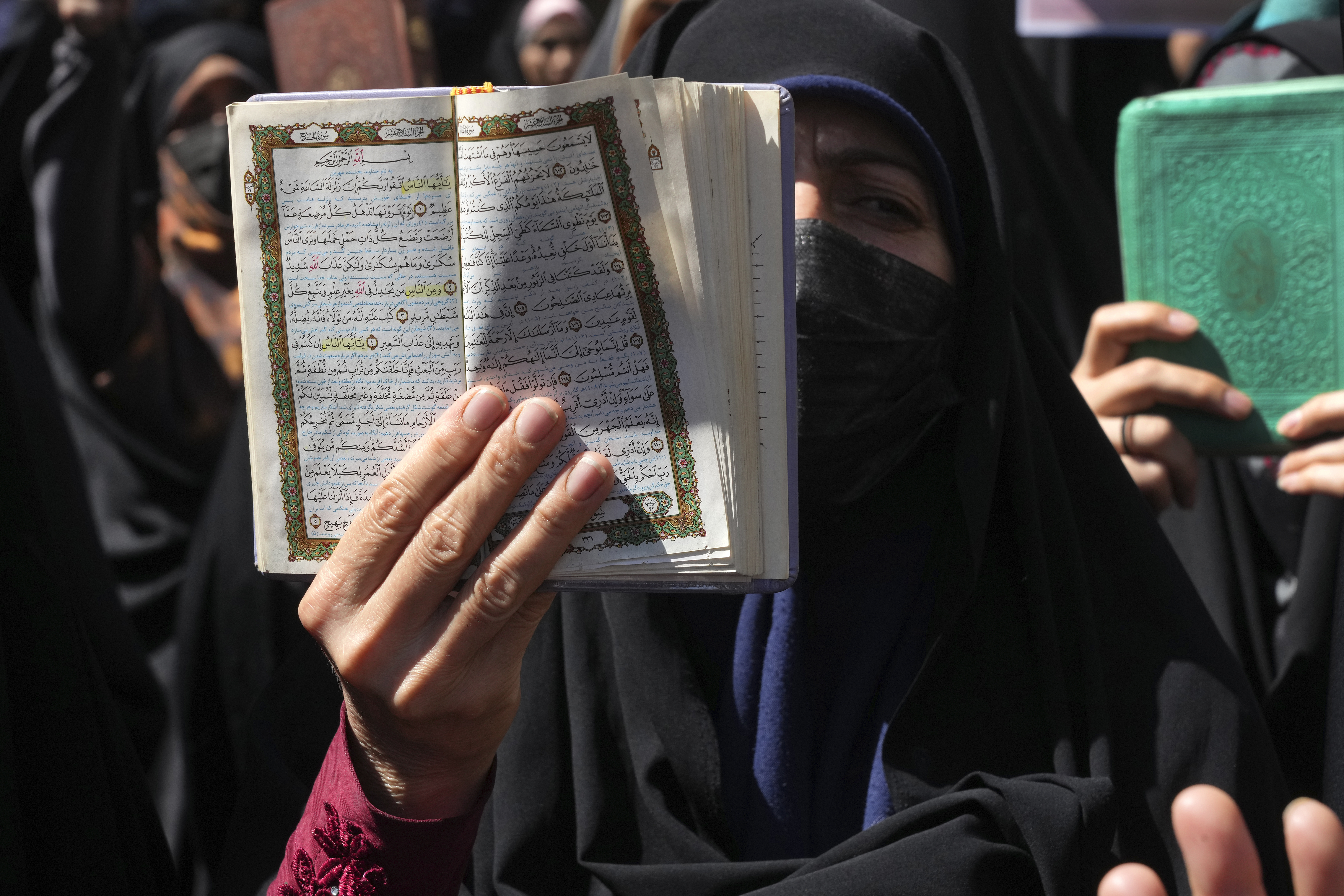 FILE -A demonstrator holds up a copy of the Quran, Islam's holy book, during a protest of the burning of a Quran in Sweden, in front of the Swedish Embassy in Tehran, Iran, June 30, 2023. (AP Photo/Vahid Salemi, File)