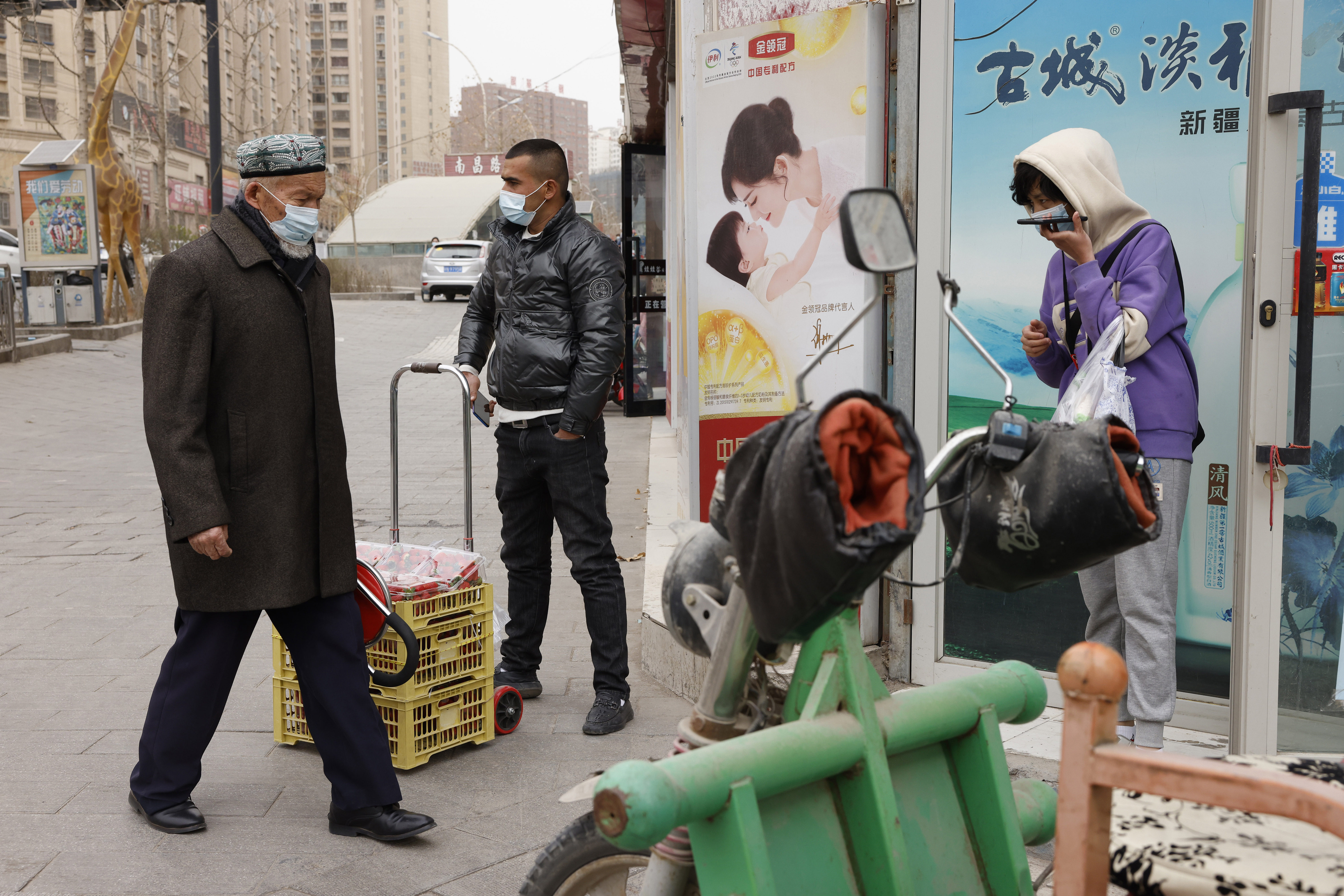 FILE - In this March 18, 2021, file photo, residents wearing masks walk along the streets of Aksu in western China's Xinjiang region. (AP Photo/Ng Han Guan, File)