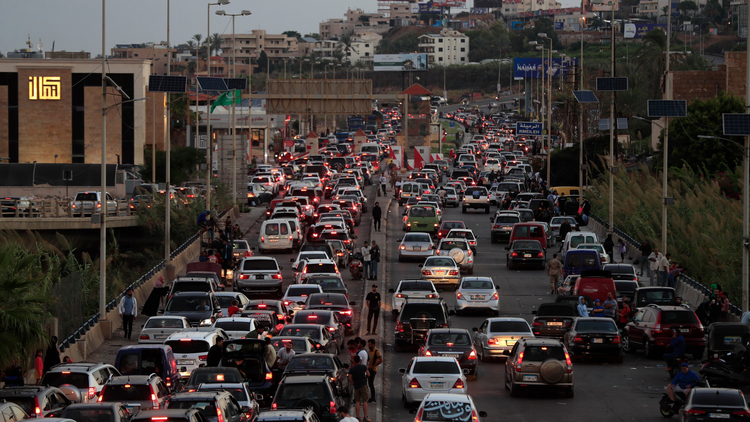 People who fled the southern villages amid ongoing Israeli airstrikes Monday, sit in their cars as they are stuck in traffic at a highway that links to Beirut city, in the southern port city of Sidon, Lebanon, Tuesday, Sept. 24, 2024. (AP Photo/Mohammed Zaatari)