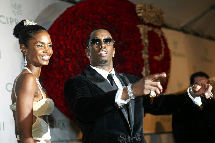 FILE - Sean "P. Diddy" Combs directs photographers as they sing "Happy Birthday," to him as his date Kim Porter, left, listens, after Combs arrived for his 35th birthday celebration at Cipriani on Wall Street in New York, Nov. 4, 2004. (AP Photo/Kathy Willens, File)