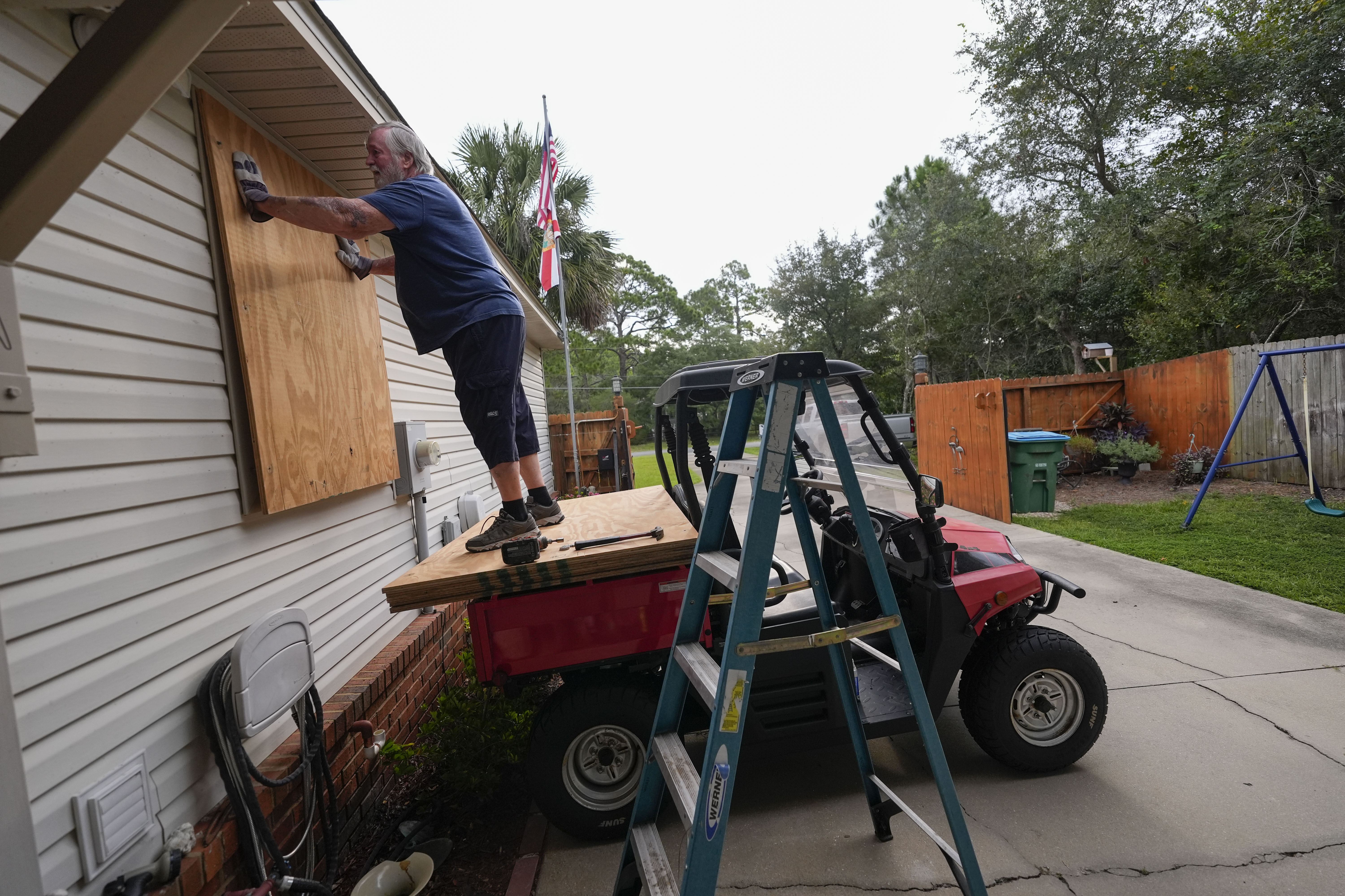 Dave McCurley boards up the windows to his home in advance of Tropical Storm Helene, expected to make landfall as a hurricane, in Ochlockonee Bay, Fla., Wednesday, Sept. 25, 2024. (AP Photo/Gerald Herbert)