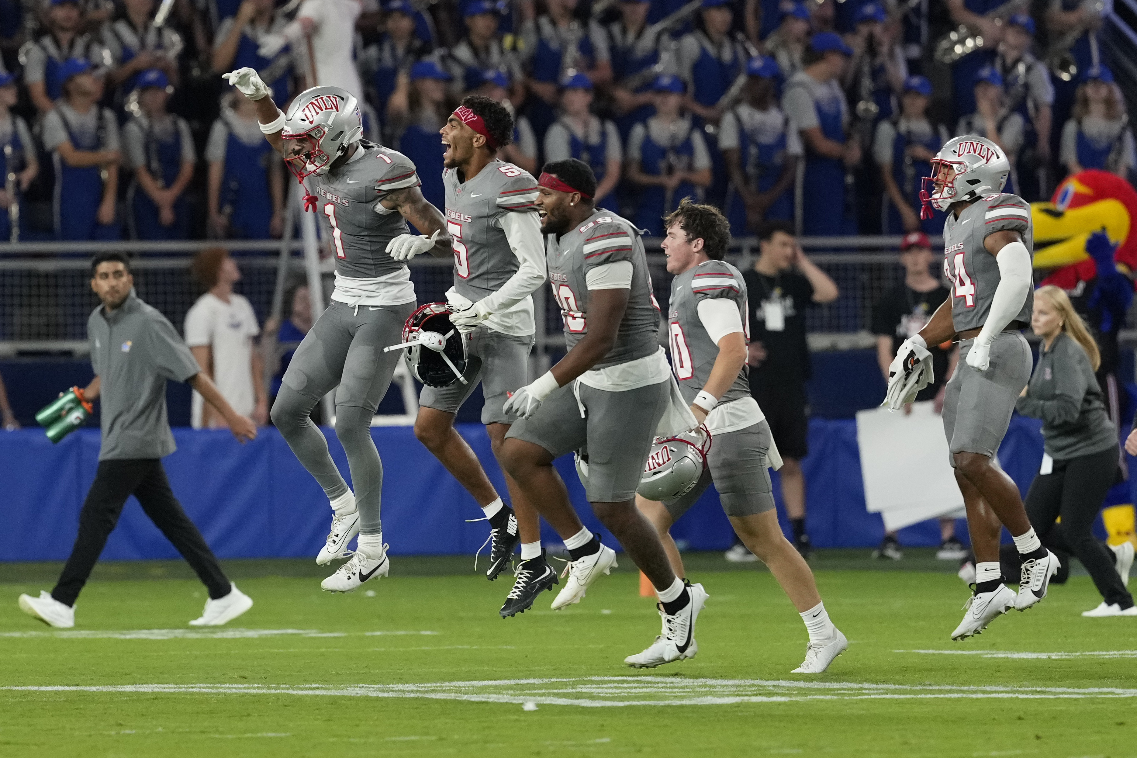 Members of UNLV run onto the field after a 23-20 win over Kansas during an NCAA college football game, Friday, Sept. 13, 2024, at Children's Mercy Park in Kansas City, Kan. (AP Photo/Ed Zurga)