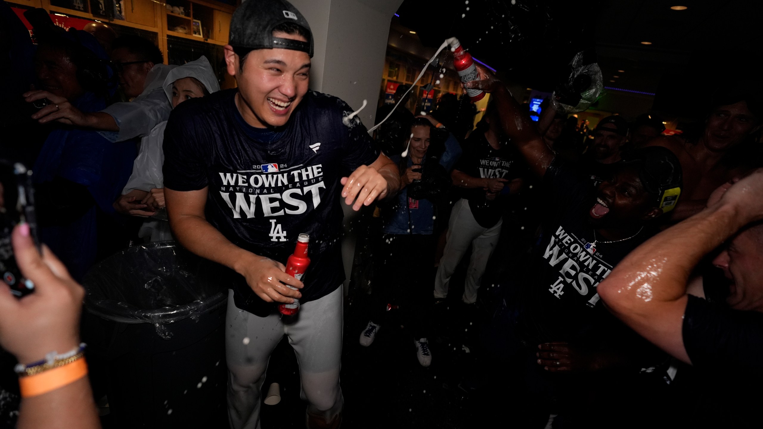 Los Angeles Dodgers designated hitter Shohei Ohtani celebrates with teammates after the Dodgers defeated the San Diego Padres 7-2 in a baseball game to clinch the National League West division Thursday, Sept. 26, 2024, in Los Angeles. (AP Photo/Ashley Landis)