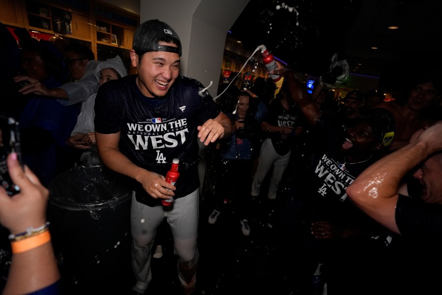 Los Angeles Dodgers designated hitter Shohei Ohtani celebrates with teammates after the Dodgers defeated the San Diego Padres 7-2 in a baseball game to clinch the National League West division Thursday, Sept. 26, 2024, in Los Angeles. (AP Photo/Ashley Landis)