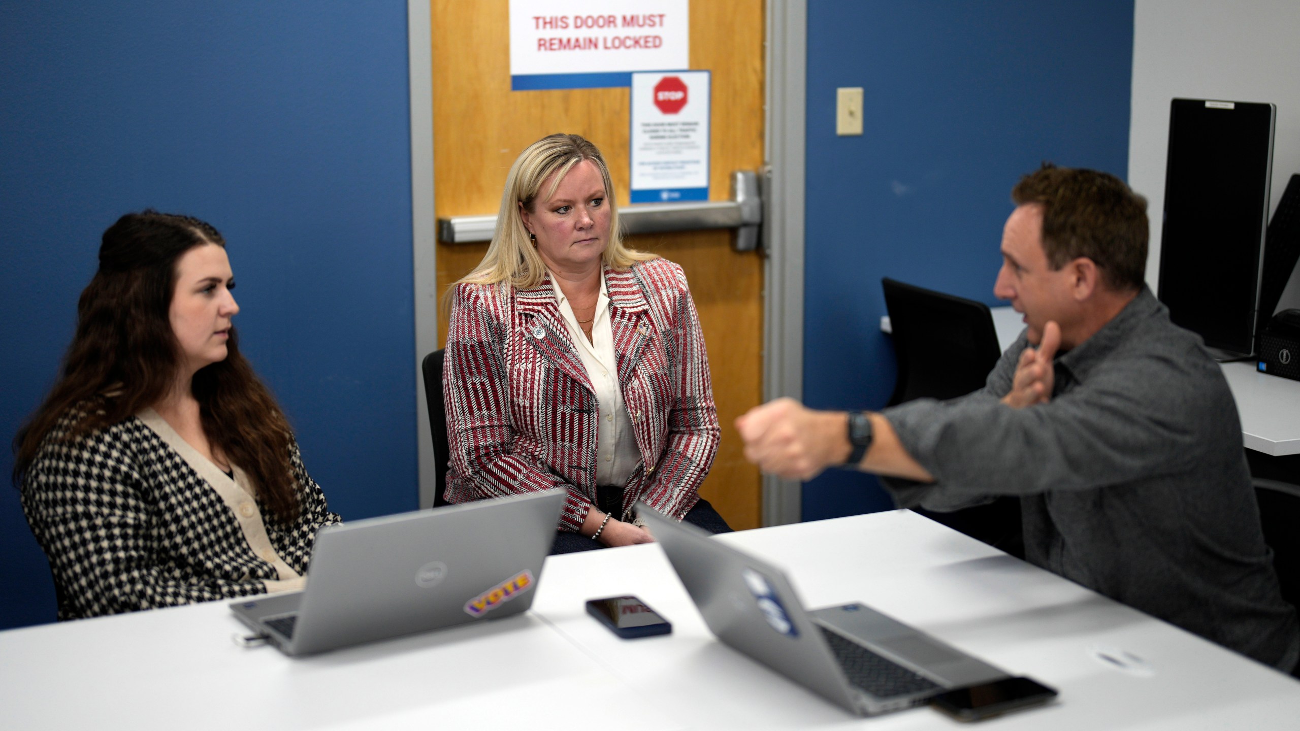 Cari-Ann Burgess, center, interim Registrar of Voters for Washoe County, Nev., speaks with Andrew McDonald, right, Deputy Registrar of Voters and Addie Vetter, elections specialist, Sept. 20, 2024, in Reno, Nev. (AP Photo/John Locher)