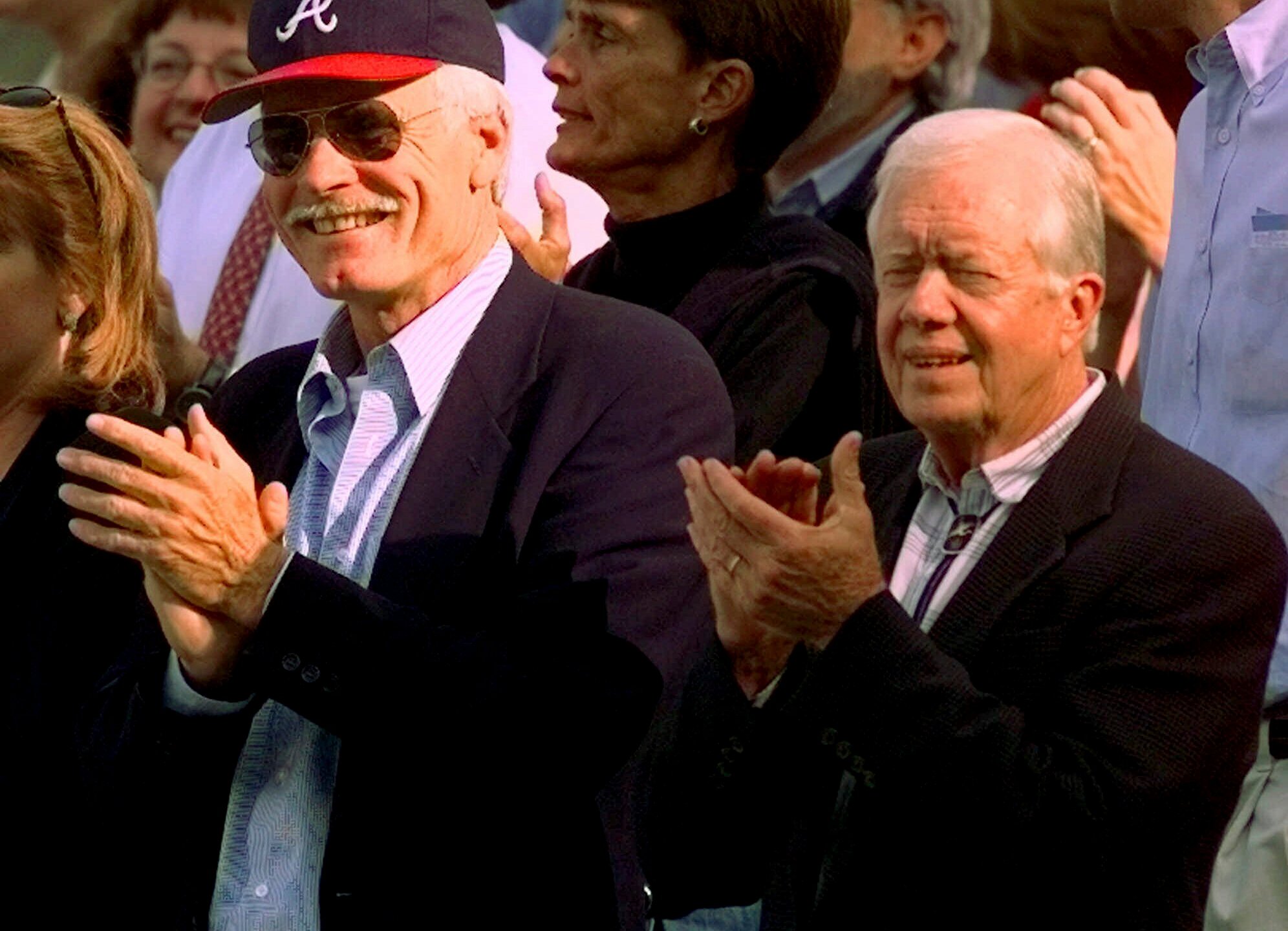 FILE - Former President Jimmy Carter, right, and Atlanta Braves team owner Ted Turner, left, watch early play during Game 6 of the National League Championship Series in Atlanta, Oct. 14, 1998. (AP Photo/Pat Sullivan, File)