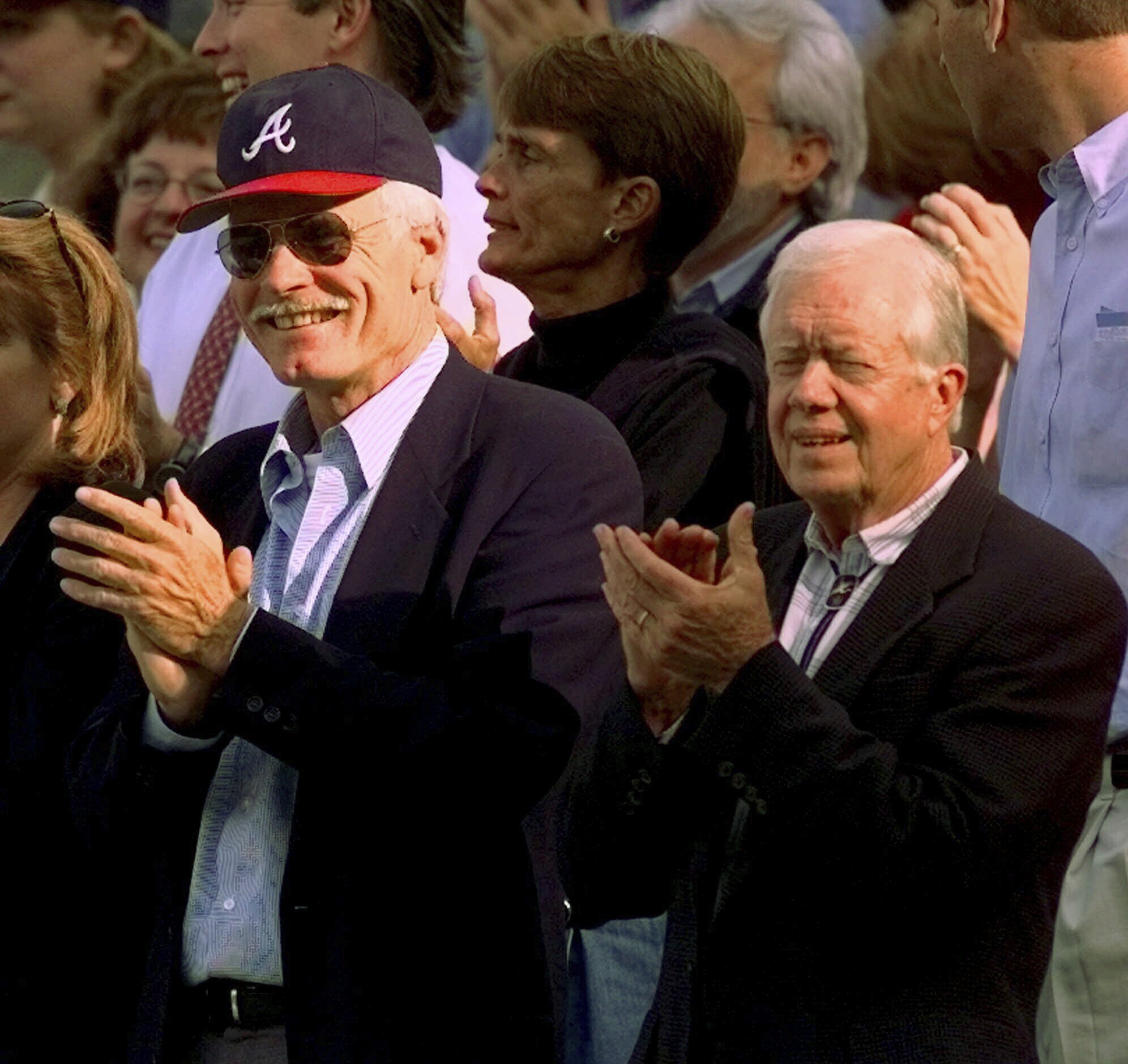 FILE - Former President Jimmy Carter, right, and Atlanta Braves team owner Ted Turner, left, watch early play during Game 6 of the National League Championship Series in Atlanta, Oct. 14, 1998. (AP Photo/Pat Sullivan, File)