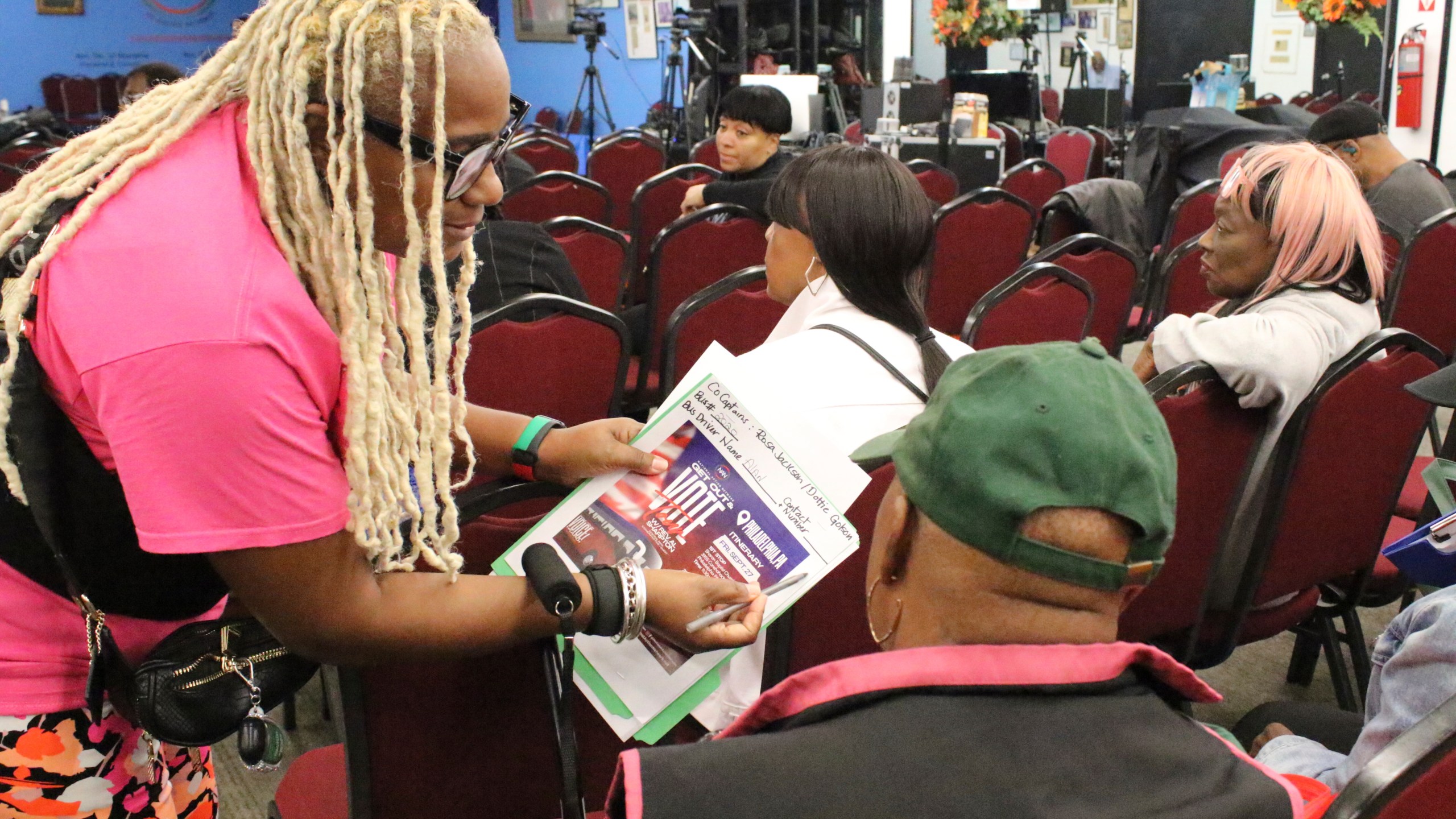 An organizer with the National Action Network signs people in ahead of a Get Out the Vote bus tour toward Philadelphia in the Harlem neighborhood of New York on Friday, Sep. 27, 2024. (AP Photo/Noreen Nasir)