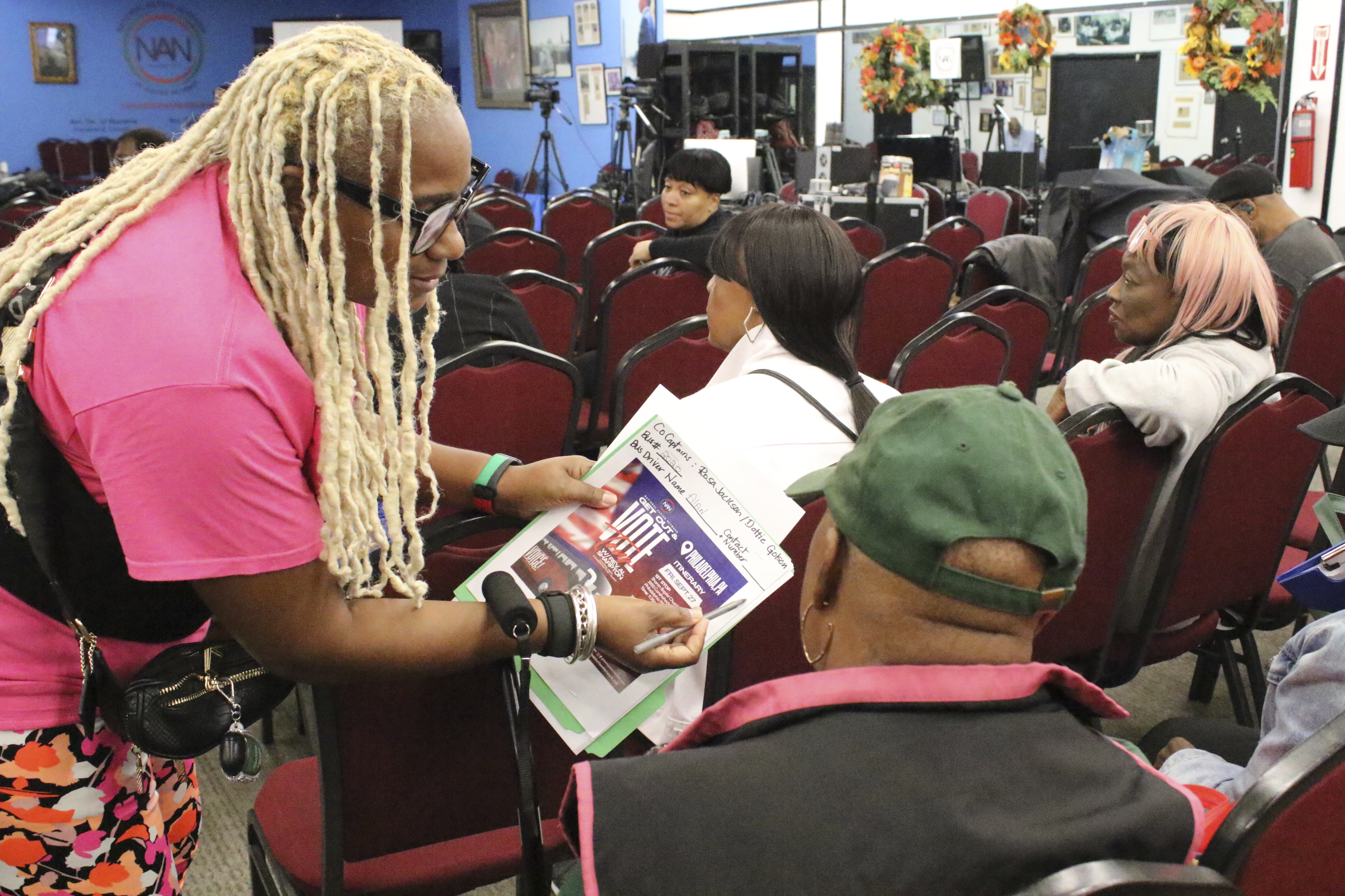 An organizer with the National Action Network signs people in ahead of a Get Out the Vote bus tour toward Philadelphia in the Harlem neighborhood of New York on Friday, Sep. 27, 2024. (AP Photo/Noreen Nasir)