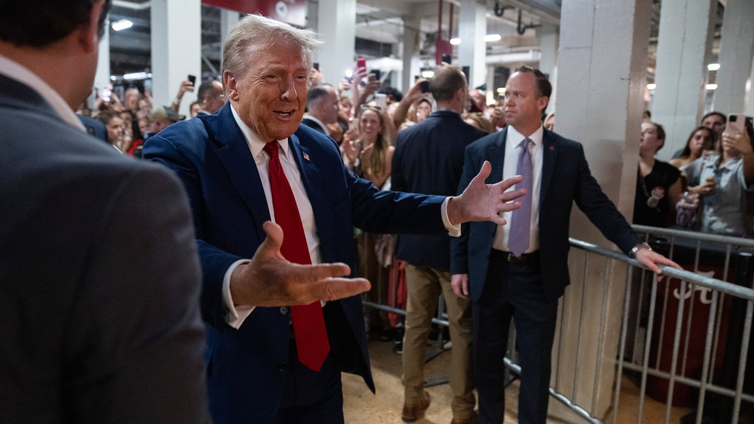 Republican presidential nominee former President Donald Trump walks to a concession stand during the Georgia vs. Alabama football game at Bryant-Denny Stadium, Saturday, Sept. 28, 2024, in Tuscaloosa, Ala. (AP Photo/Evan Vucci)