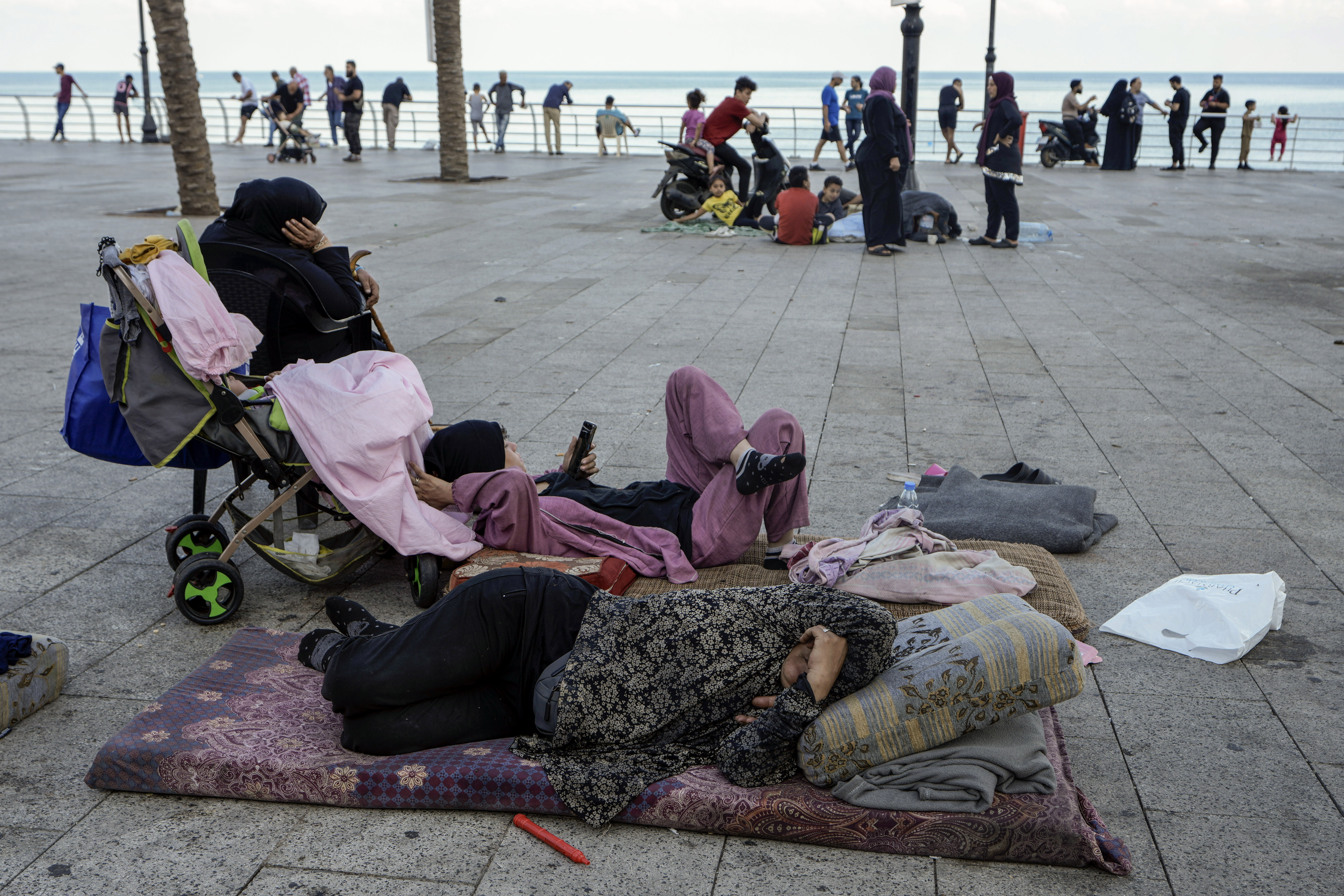 Families sleep on Beirut's corniche after fleeing the Israeli airstrikes in the southern suburbs of Dahiyeh, Sunday, Sept. 29, 2024. (AP Photo/Bilal Hussein)