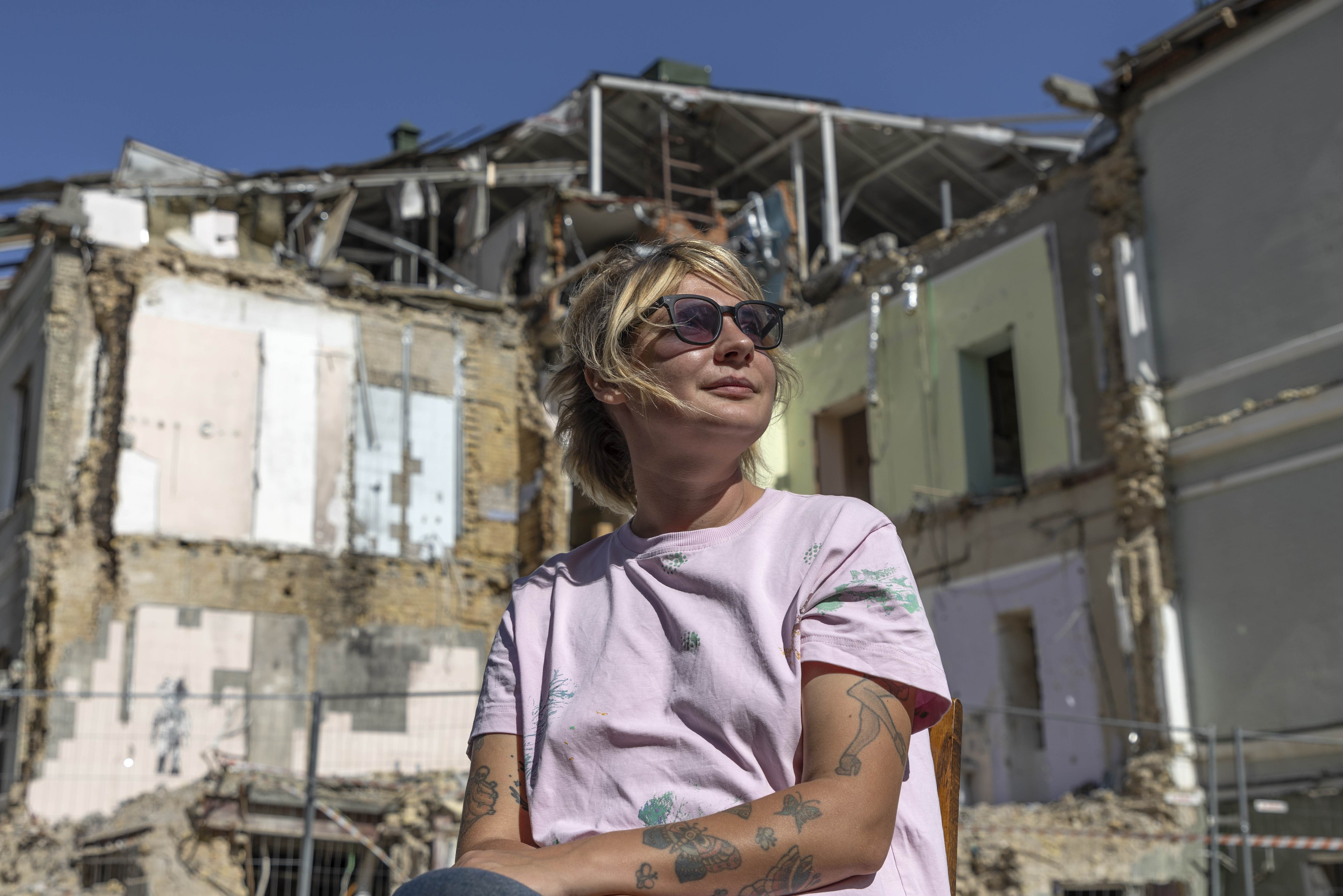 Olha Bulkina, 35, co-founder of the "Bureau of Smiles and Support" sits in front of Okhmatdyt children's hospital in Kyiv, Ukraine Saturday Sept. 14, 2024 which was destroyed after a Russian missile strike on July 8. (AP Photo/Anton Shtuka)