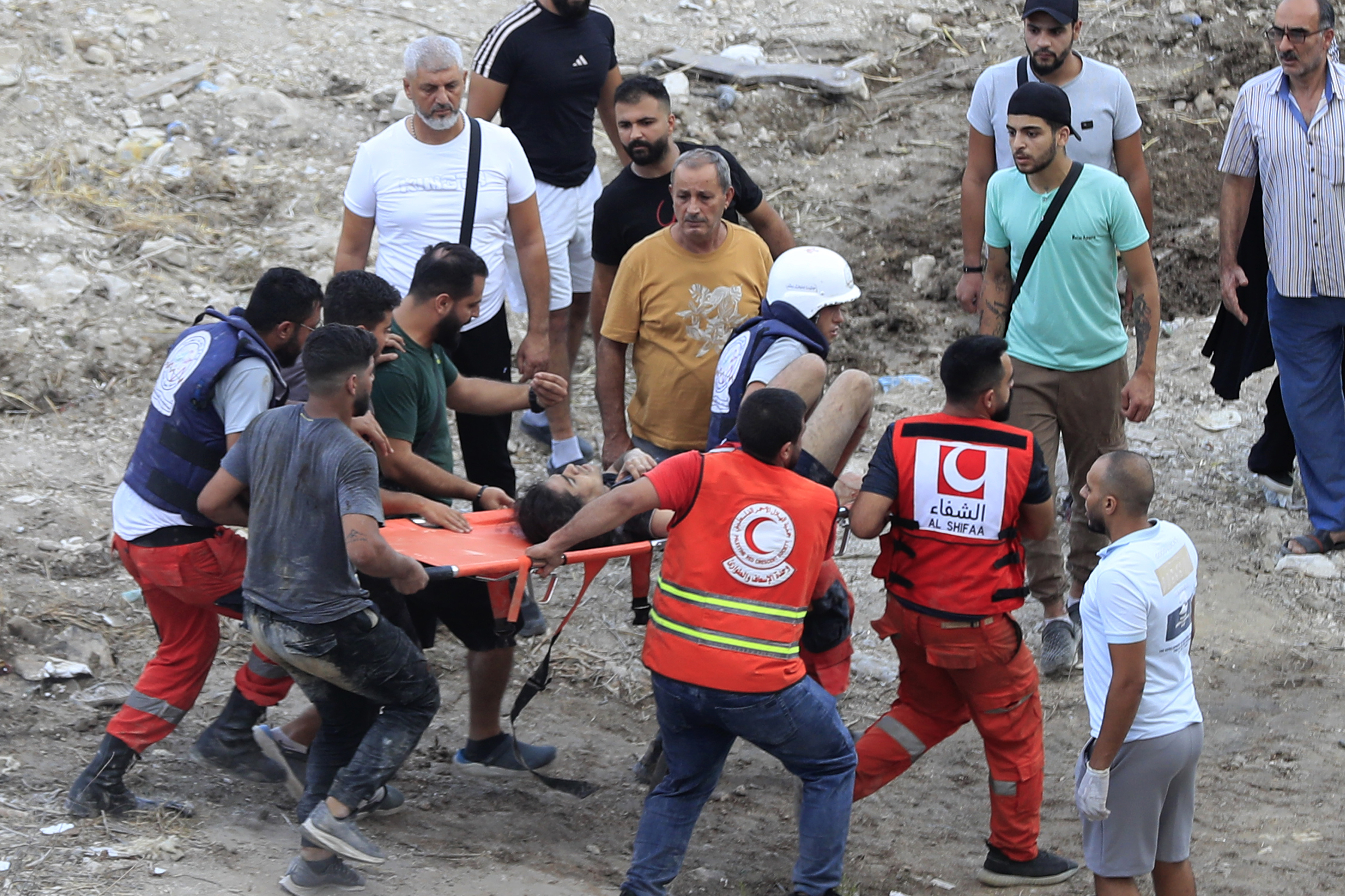 Rescue workers carry a man who was injured after an Israeli airstrike hit two adjacent buildings, in Ain el-Delb neighbourhood east of the southern port city of Sidon, Lebanon, Sunday, Sept. 29, 2024. (AP Photo/Mohammed Zaatari)