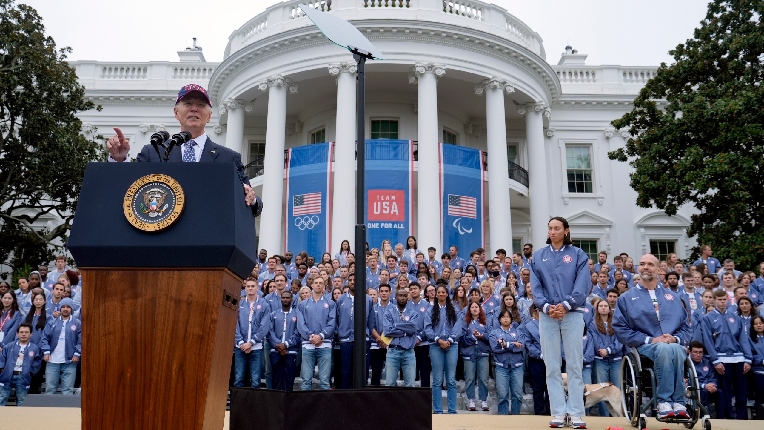 President Joe Biden, from left, speaks as Olympic swimmer Torri Huske and Paralympian basketball players Paul Schulte listen during at an event celebrating the 2024 U.S. Olympic and Paralympic teams on the South Lawn of the White House in Washington, Monday, Sept. 30, 2024. (AP Photo/Susan Walsh)