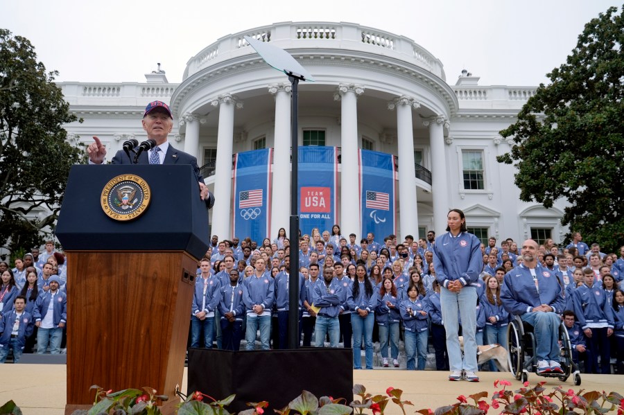 President Joe Biden, from left, speaks as Olympic swimmer Torri Huske and Paralympian basketball players Paul Schulte listen during at an event celebrating the 2024 U.S. Olympic and Paralympic teams on the South Lawn of the White House in Washington, Monday, Sept. 30, 2024. (AP Photo/Susan Walsh)