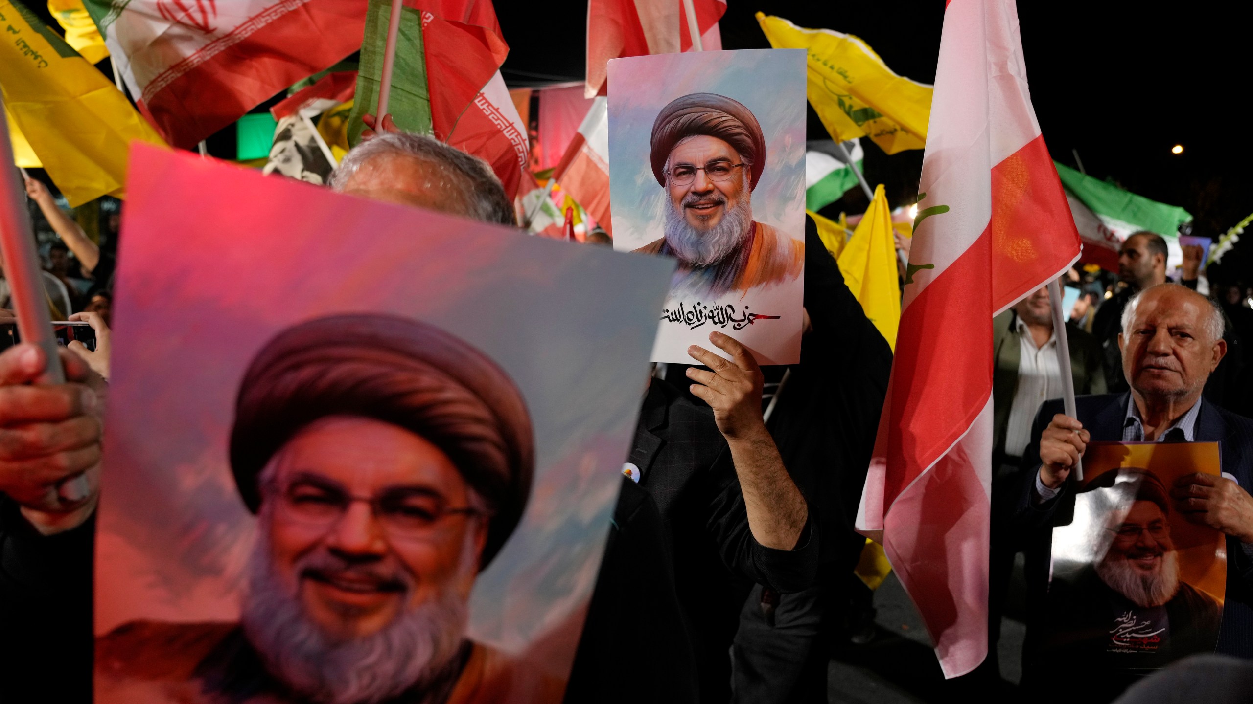 Iranian demonstrators hold posters of slain Hezbollah leader Hassan Nasrallah during an anti-Israeli protest at Felestin (Palestine) Square in Tehran, Iran, Tuesday, Oct. 1, 2024. (AP Photo/Vahid Salemi)