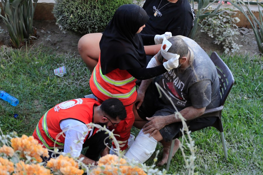 FILE - Paramedics treat a man who was injured after an Israeli airstrike hit two adjacent buildings east of the southern port city of Sidon, Lebanon, Sunday, Sept. 29, 2024. (AP Photo/Mohammed Zaatari, File)