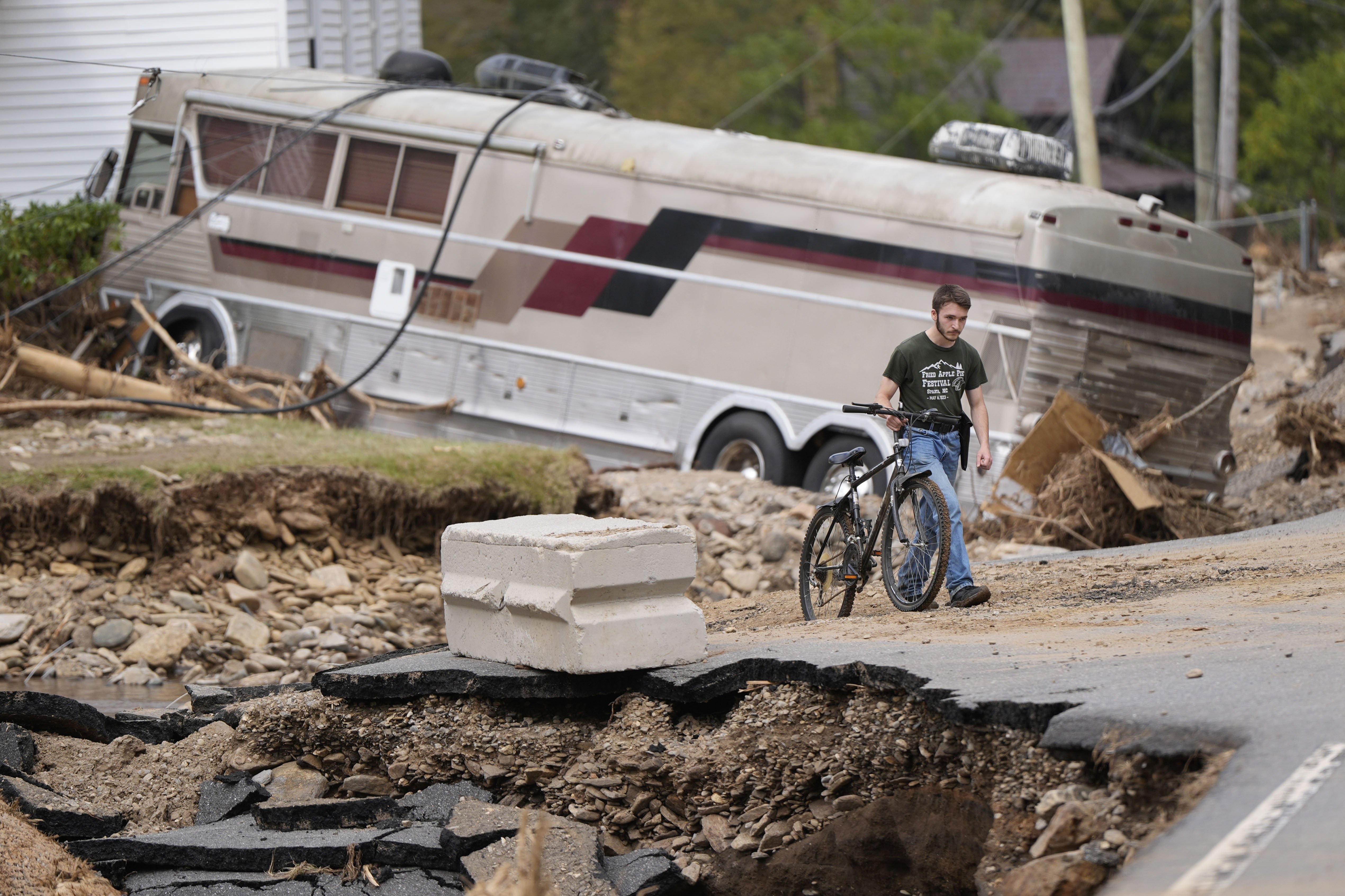 Dominick Gucciardo walks to his home in the aftermath of Hurricane Helene, Thursday, Oct. 3, 2024, in Pensacola, N.C. (AP Photo/Mike Stewart)