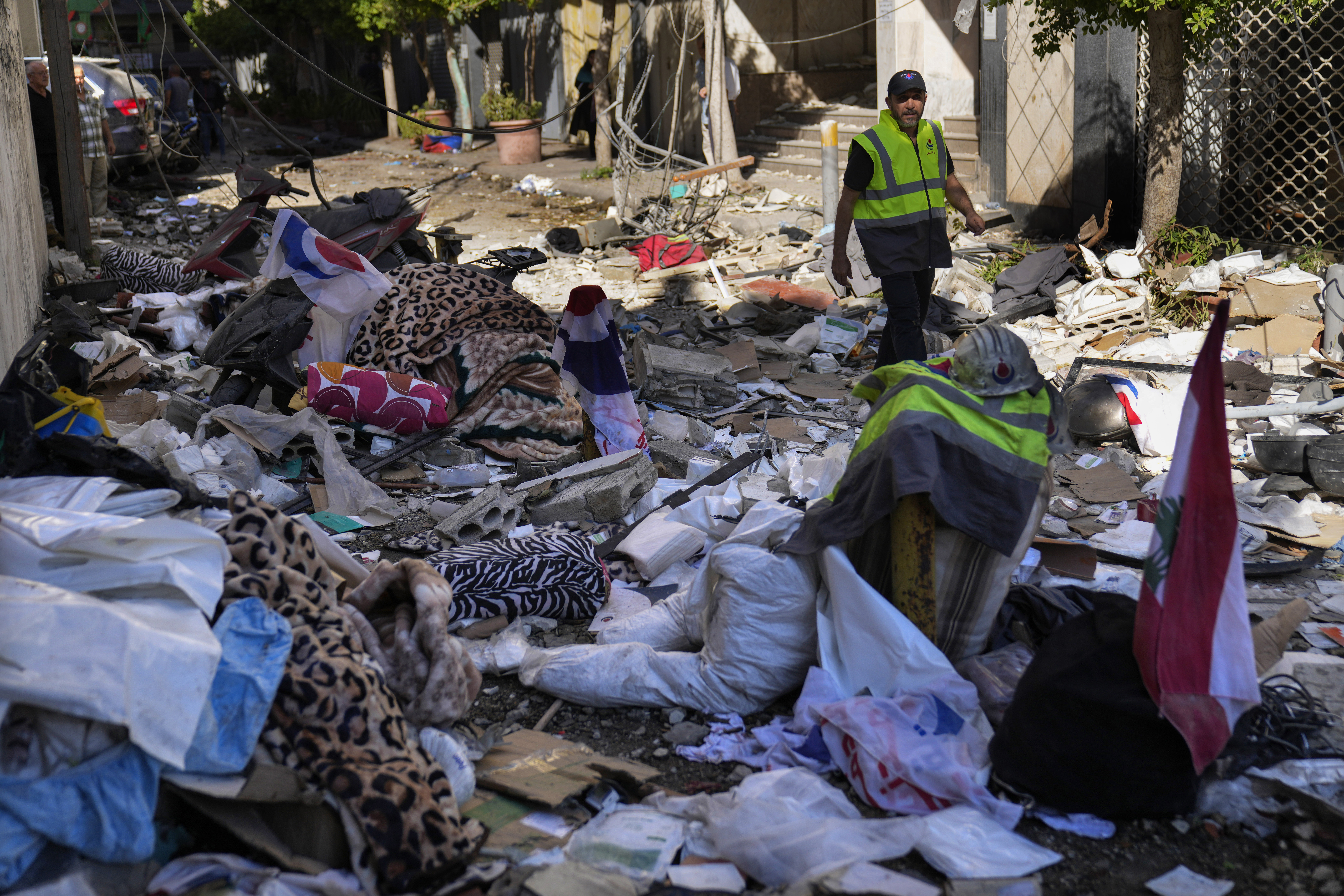 A Hezbollah paramedic walks between debris after an airstrike hit an apartment in a multistory building, in central Beirut, Lebanon, Thursday, Oct. 3, 2024. (AP Photo/Hussein Malla)