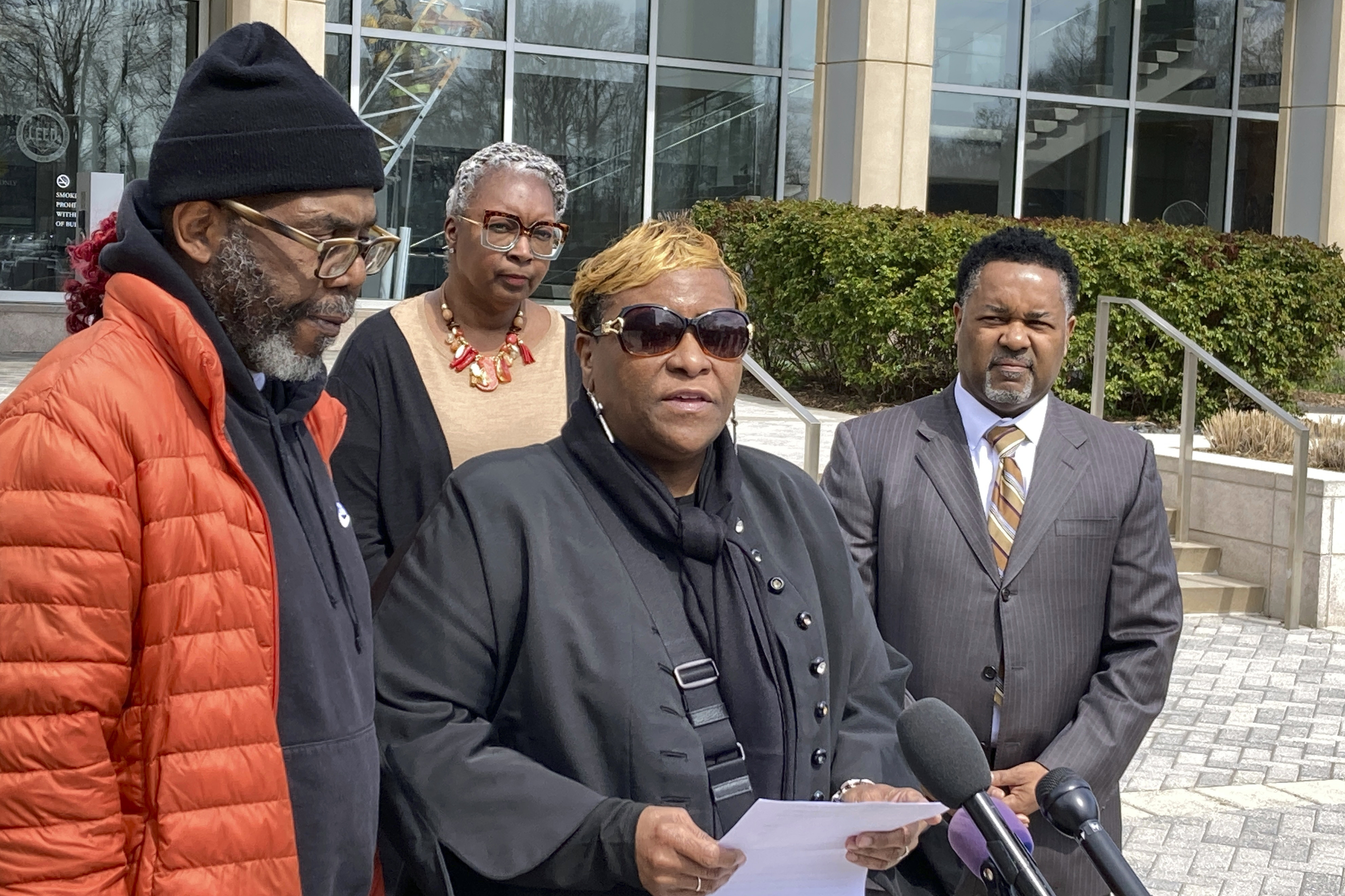 FILE - Timothy McCree Johnson's parents Melissa Johnson, center, and Timothy Walker, left, address reporters along with attorney Carl Crews, right, outside Fairfax County Police headquarters, March 22, 2023, in Fairfax, Va. (AP Photo/Matthew Barakat, File)