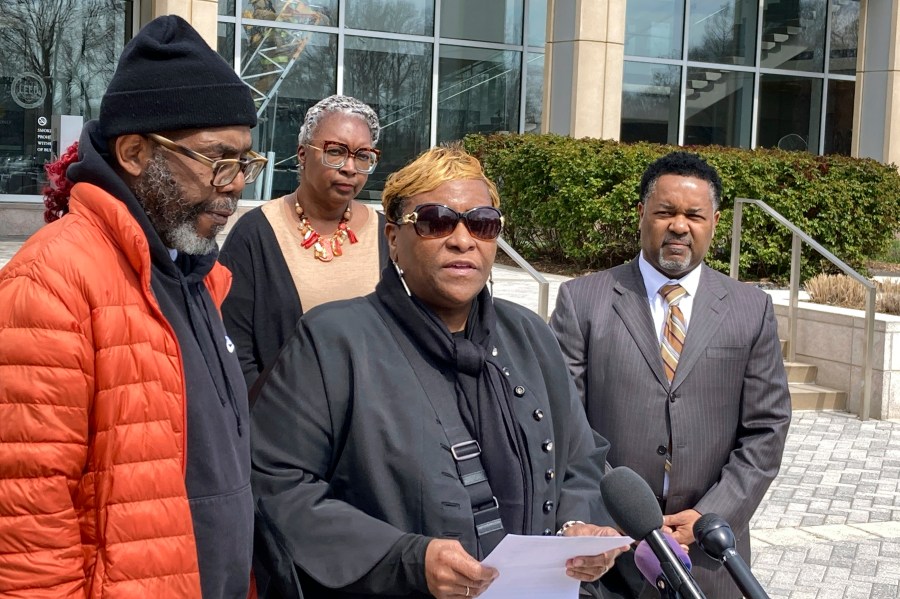 FILE - Timothy McCree Johnson's parents Melissa Johnson, center, and Timothy Walker, left, address reporters along with attorney Carl Crews, right, outside Fairfax County Police headquarters, March 22, 2023, in Fairfax, Va. (AP Photo/Matthew Barakat, File)