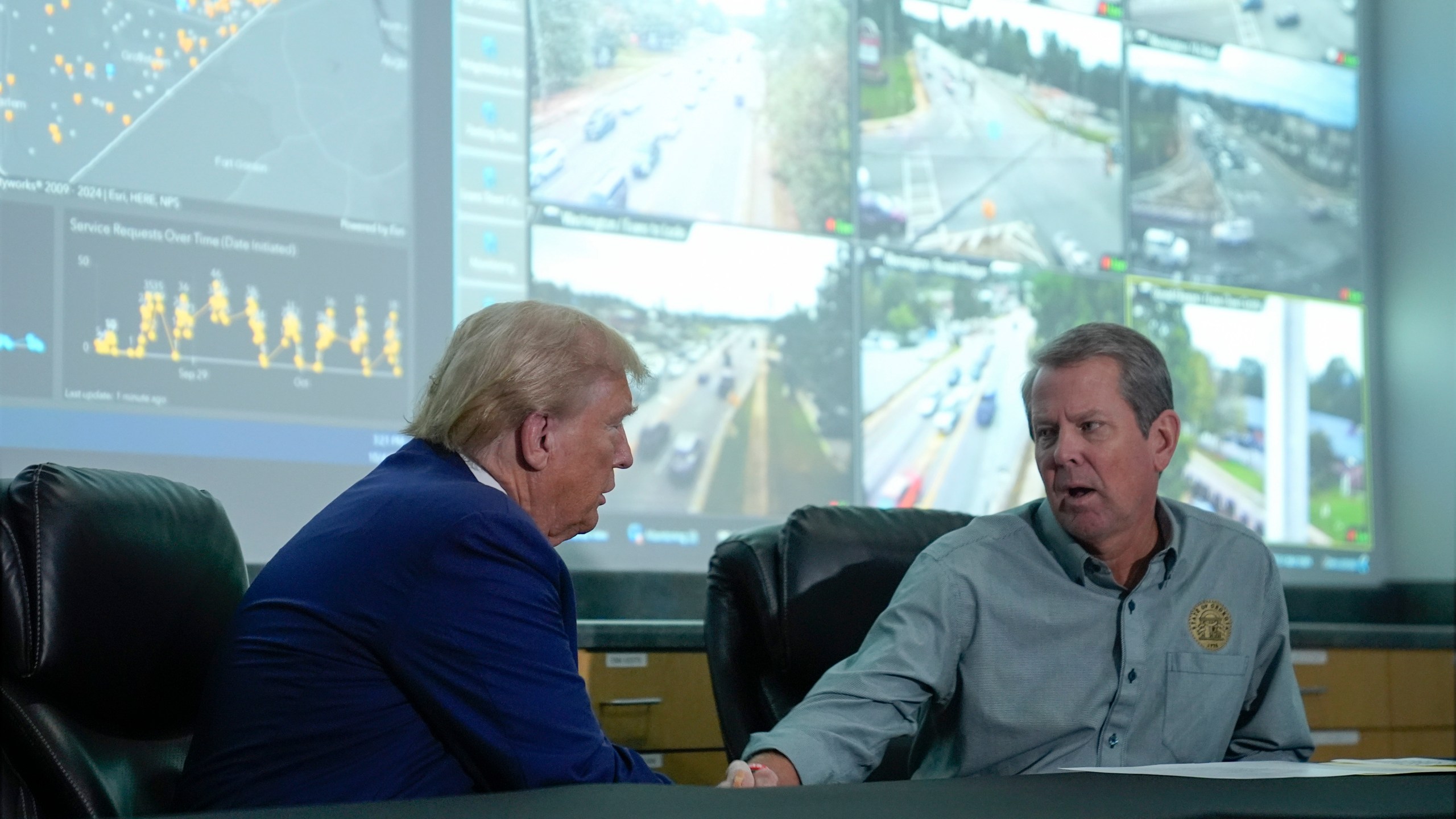 Republican presidential nominee former President Donald Trump talks with Georgia Gov. Brian Kemp during a briefing at the Columbia County Emergency Management Agency as he visits areas impacted by Hurricane Helene, Friday, Oct. 4, 2024, in Evans, Ga. (AP Photo/Evan Vucci)