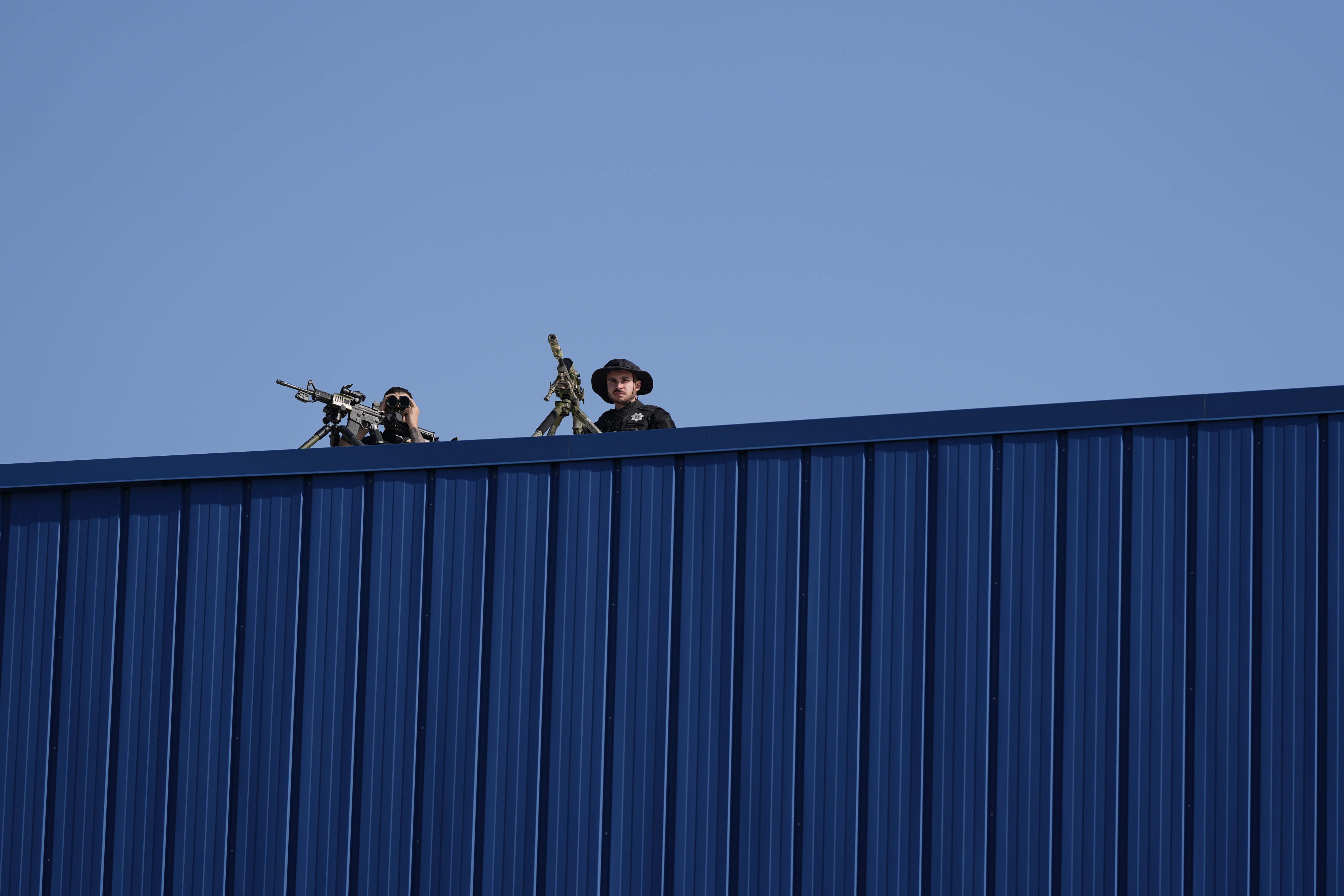 Law enforcement snipers sit on a roof before Republican presidential nominee former President Donald Trump arrives to speak at a campaign rally at Dodge County Airport, Sunday, Oct. 6, 2024, in Juneau, Wis. (AP Photo/Julia Demaree Nikhinson)