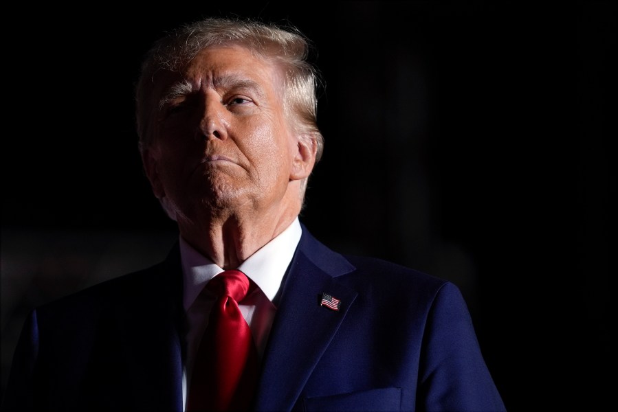 Republican presidential nominee former President Donald Trump listens to opera singer Christopher Macchio after speaking at a campaign rally at the Butler Farm Show, Saturday, Oct. 5, 2024, in Butler, Pa. (AP Photo/Evan Vucci)