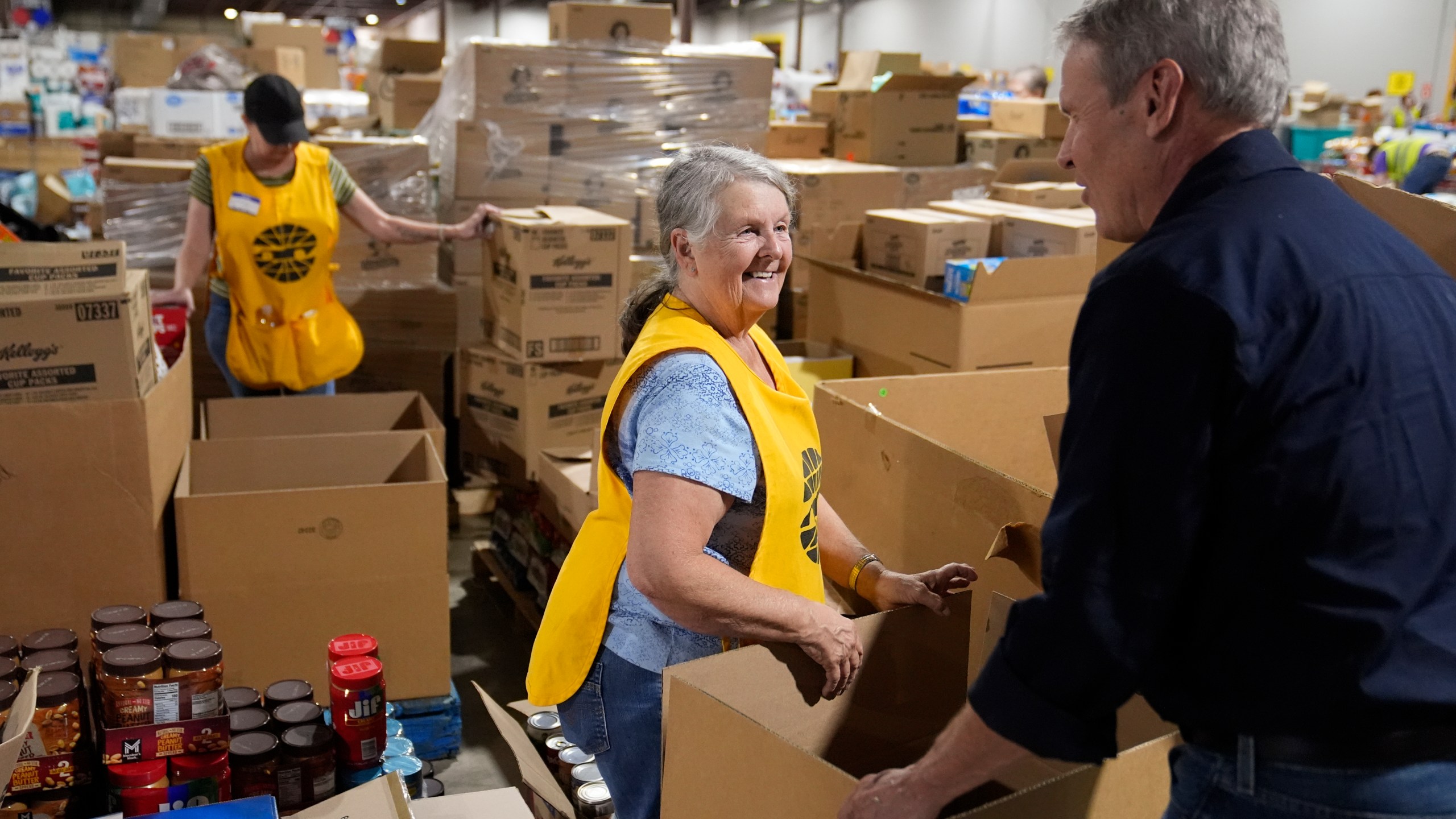 Volunteer Ann Davis speaks with Tennessee Gov. Bill Lee, right, during his visit to the East Tennessee Disaster Relief Center, for Hurricane Helene disaster response Monday, Oct. 7, 2024, in Bristol, Tenn. (AP Photo/George Walker IV via Pool)