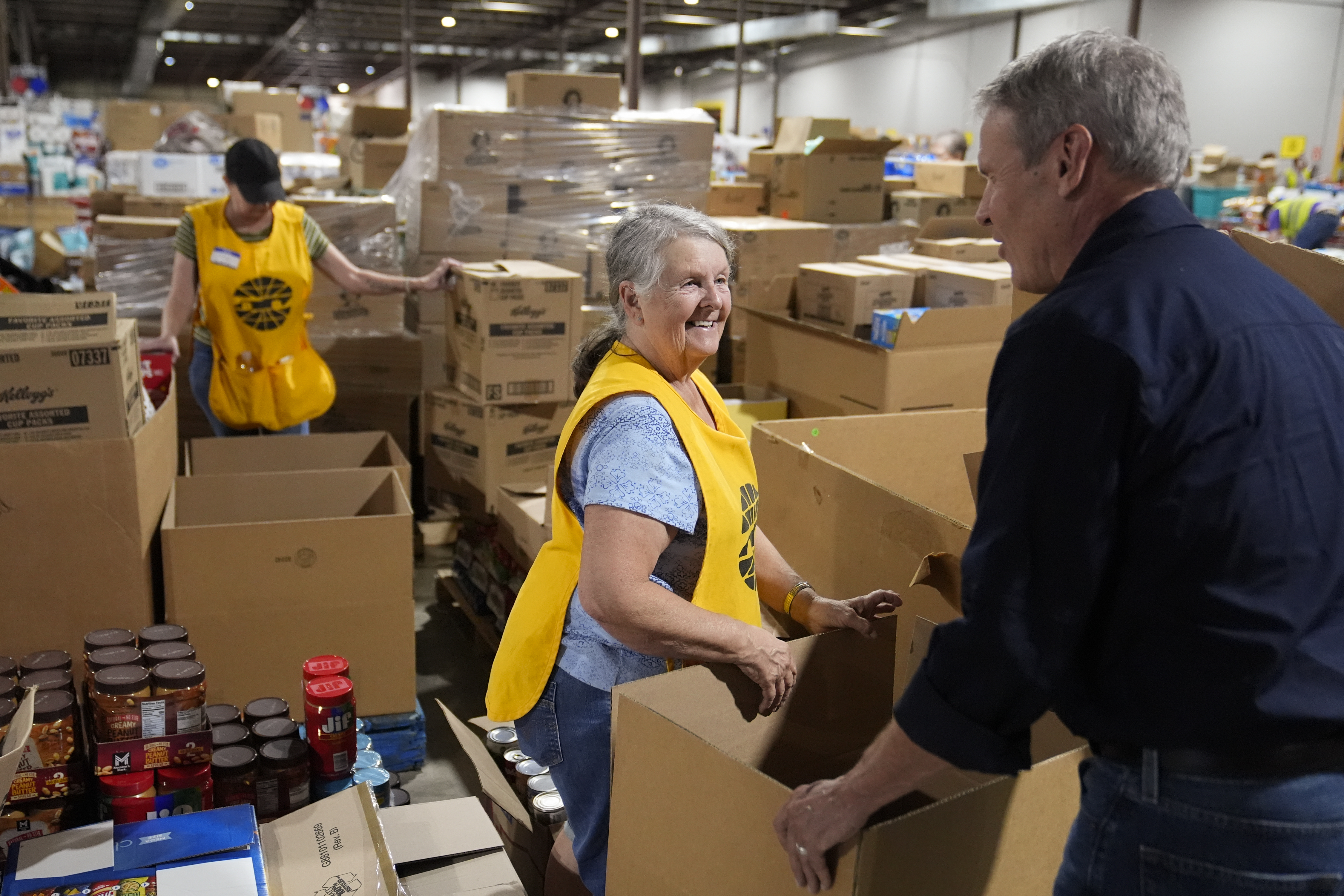 Volunteer Ann Davis speaks with Tennessee Gov. Bill Lee, right, during his visit to the East Tennessee Disaster Relief Center, for Hurricane Helene disaster response Monday, Oct. 7, 2024, in Bristol, Tenn. (AP Photo/George Walker IV via Pool)