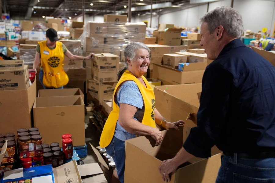 Volunteer Ann Davis speaks with Tennessee Gov. Bill Lee, right, during his visit to the East Tennessee Disaster Relief Center, for Hurricane Helene disaster response Monday, Oct. 7, 2024, in Bristol, Tenn. (AP Photo/George Walker IV via Pool)